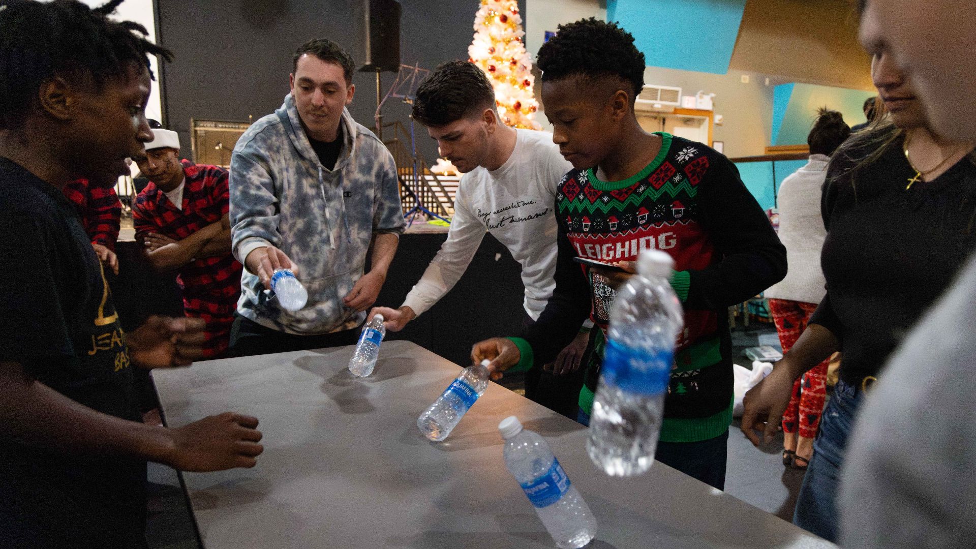 Holiday party attendees compete against each other in a bottle flipping contest during the Marine Corps Installations Pacific Headquarters and Support Battalion holiday party on Camp Foster, Okinawa, Japan, Dec. 13, 2024. H&S Bn, MCIPAC, hosted this event