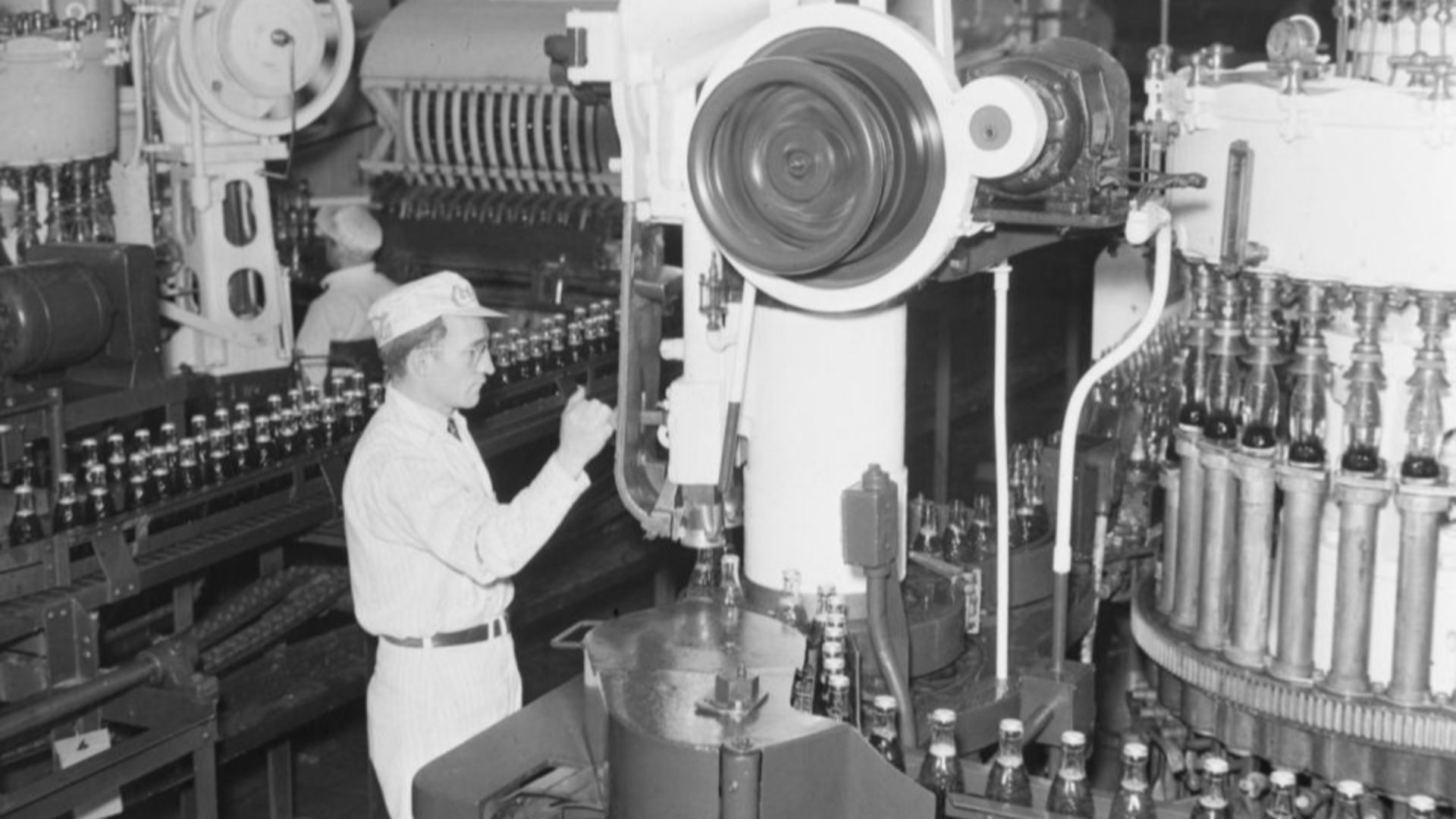 We see two employees working at bottling plant of Coca-Cola Canada Ltd. located at 200 De Bellechasse Street East in Montreal, Canada.