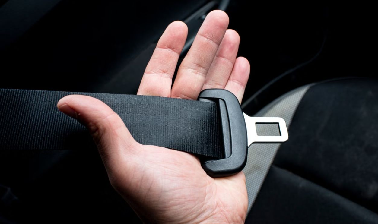 Close-up of a hand holding a car seat belt for safety and security