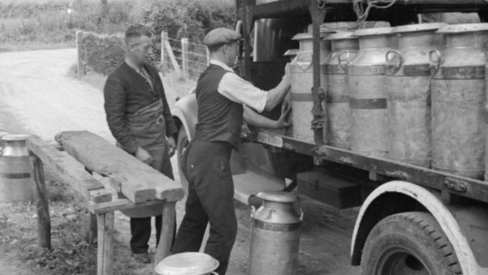 Agriculture in Britain- Life on Mount Barton Farm, Devon, England, 1942
A farmer helps load milk churns onto the lorry that will take them to the local town for delivery.  The lorry driver can be seen on the left.