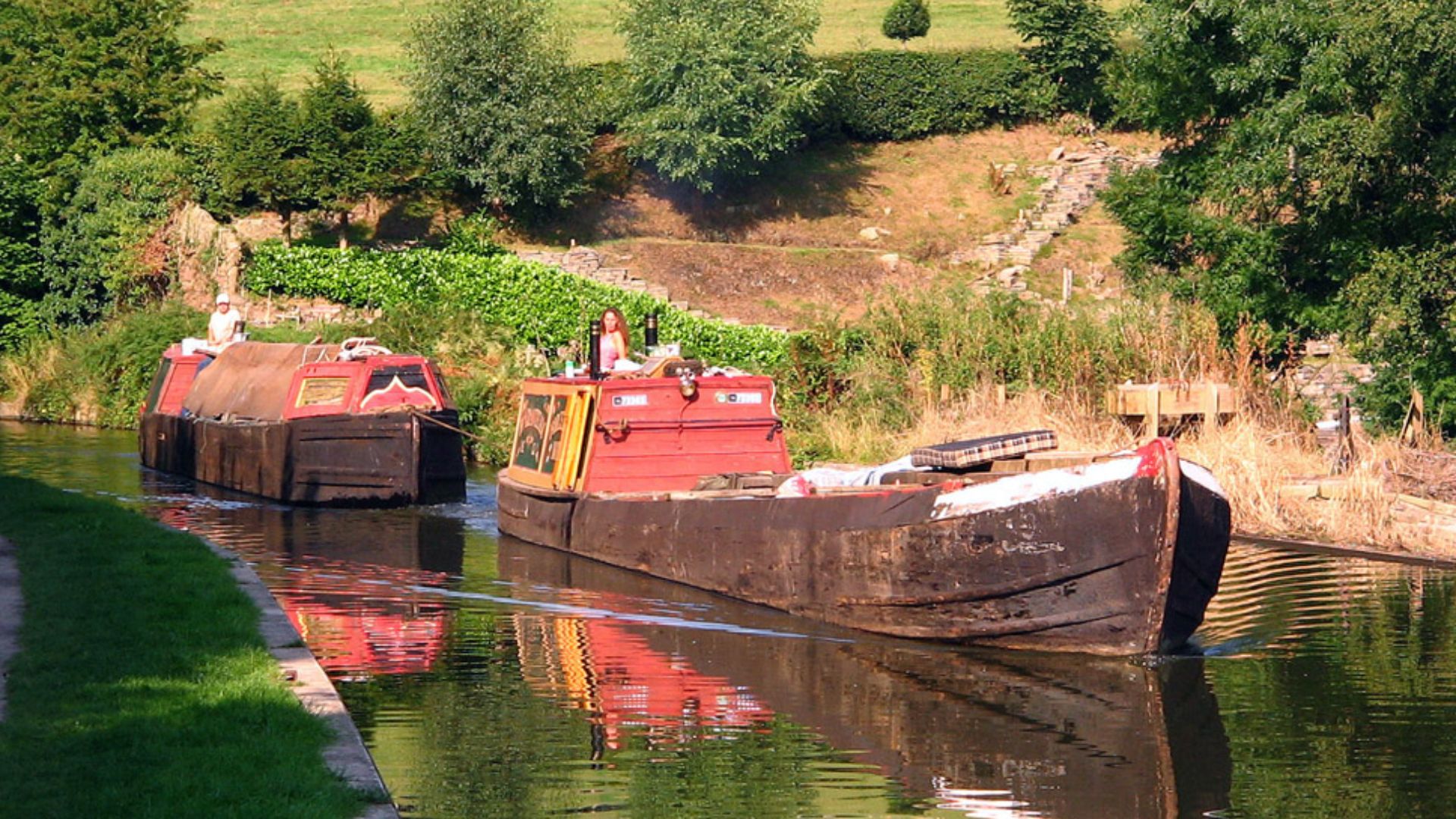 Historic working narrowboats on the Macclesfield Canal in Cheshire, England.
The motor boat at the front