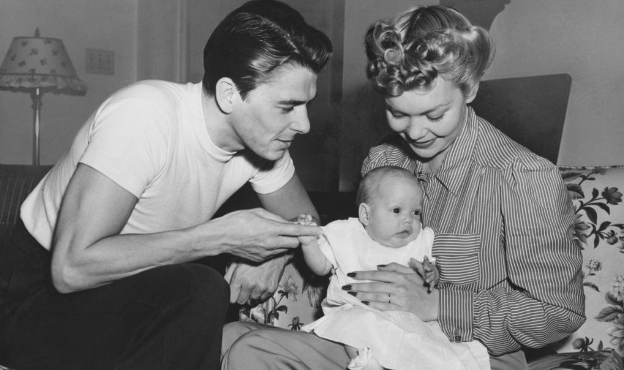 American actor and politician Ronald Reagan (1911-2004), wearing a white t-shirt, with his wife, American actress Jane Wyman (1917-2007), who wears a striped blouse, and their daughter Maureen Reagan (1941-2001), who sits in Wyman's lap, at home in Los Angeles, California, 1941. Ronald Reagan would later serve as the 40th President of the United States.