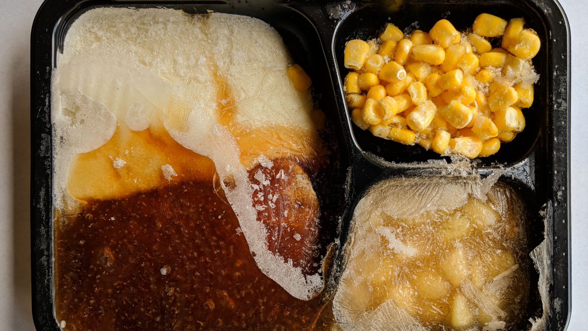 Top view of an opened, uncooked TV dinner.