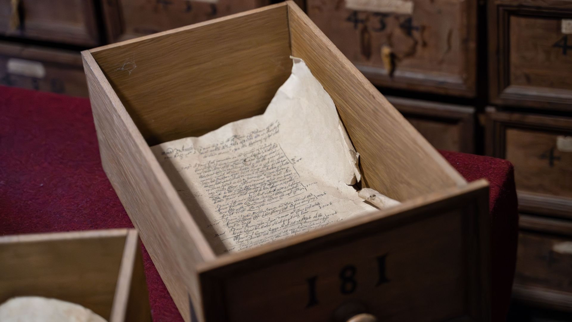 Discover an antique manuscript within a vintage wooden drawer, evoking historical charm.