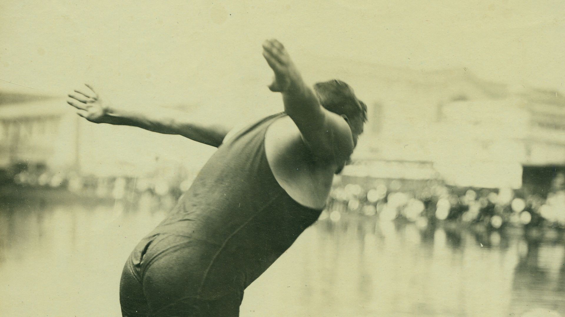 Vertical photograph of a man beginning to dive from a pillar into the water.Title: E.H. Adams, New York Athletic Club, Plunge for Distance (Swimming and Diving event at the 1904 Olympics).