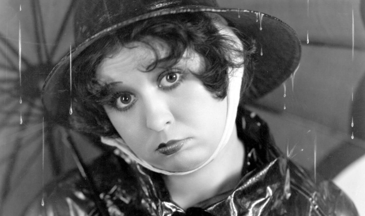 circa 1934: Helen Kane (1904-1966), formerly Helen Schroeder, the original 'boop-boopa-doop' singer and actress signed by Paramount, sheltering beneath an umbrella.