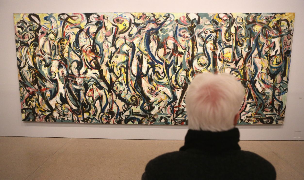 BERLIN, GERMANY - NOVEMBER 24: A visitor at the 'Jackson Pollock's Mural: Energy Made Visible' exhibition looks at Jackson Pollock's work entitled 'Mural' at the Deutsche Bank KunstHalle on November 24, 2015 in Berlin, Germany. The exhibition, which among other works includes the mural considered to have helped pave the way for the Abstract Expressionism movement, runs from November 25, 2015 until April 10, 2016.