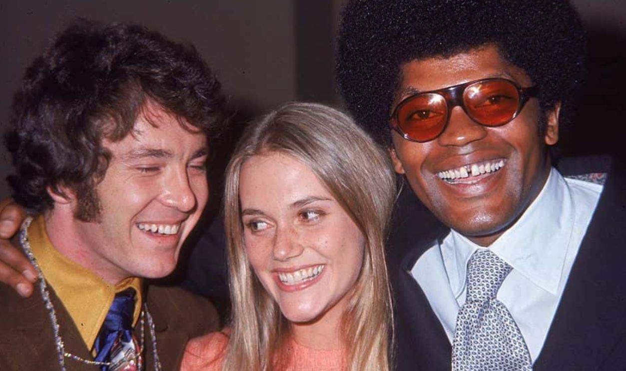 circa 1969: American actors Michael Cole (left), Peggy Lipton and Clarence Williams III, all cast members from the television program, 'The Mod Squad,' smile while embracing