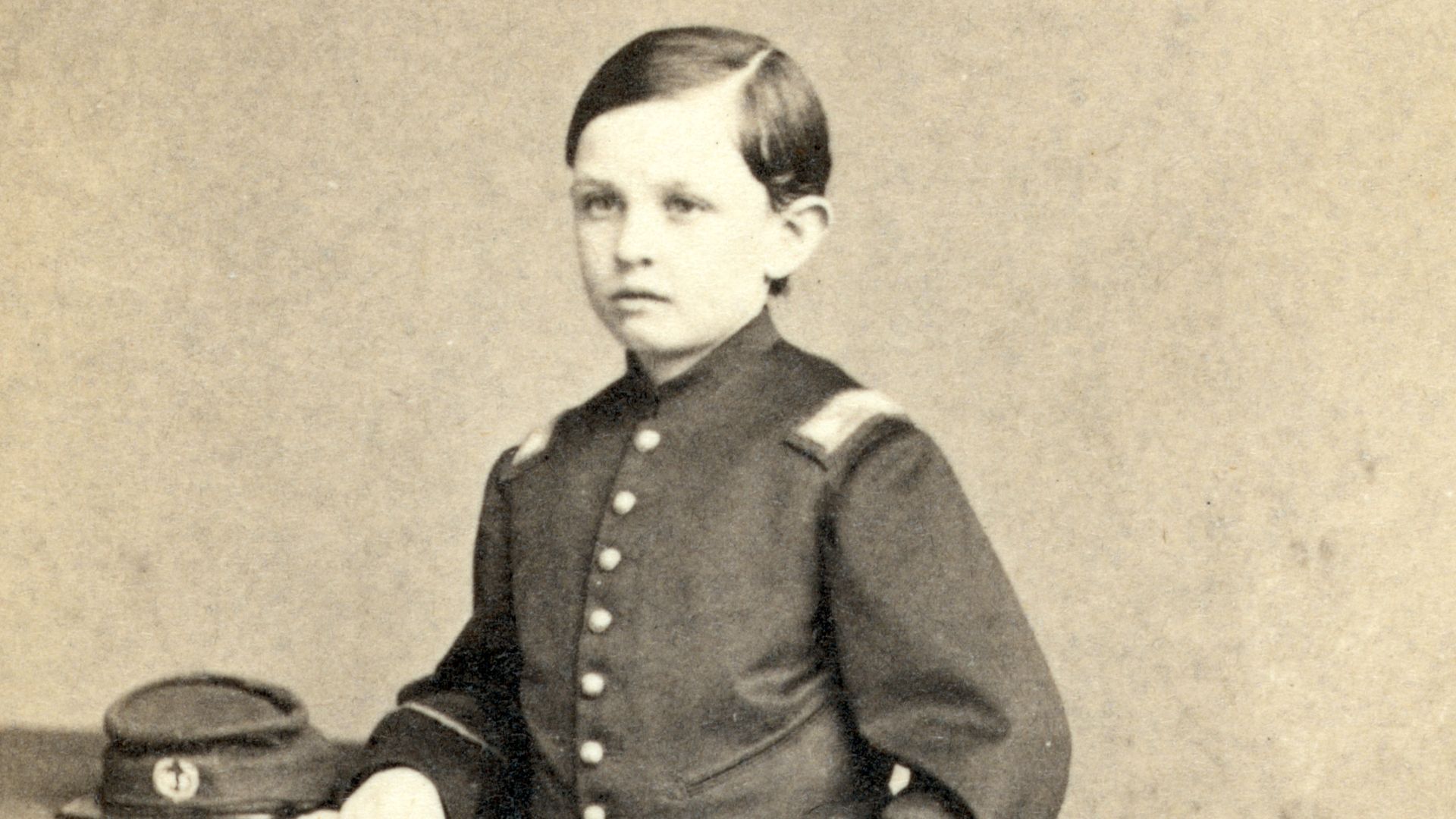 Photograph showing portrait of Tad Lincoln, standing, wearing a military-style uniform. Albumen, on carte de visite mount ; 10 x 6 cm. Cropped, histogram fix