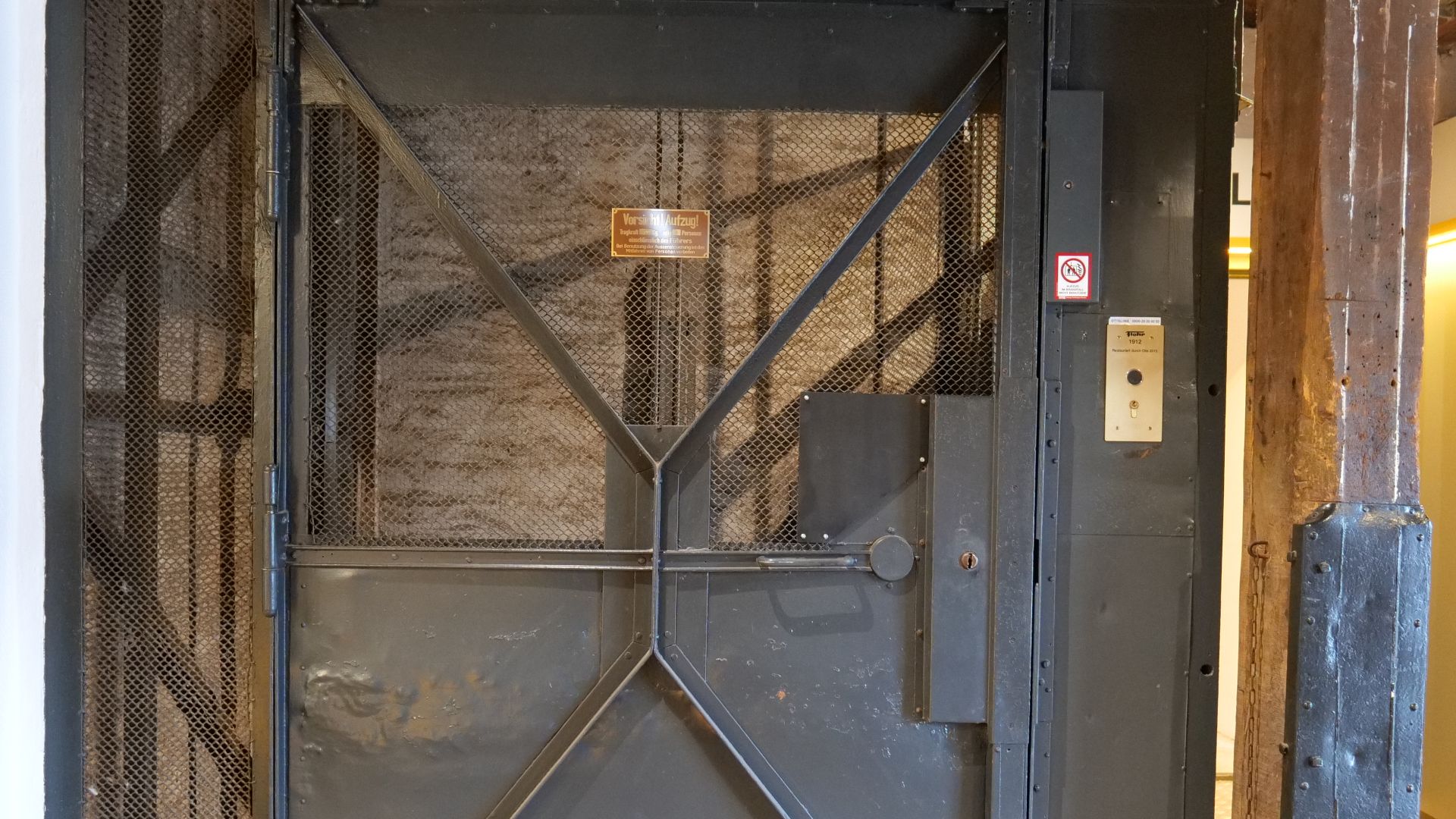 This freight elevator from the Flohr company dating back to 1912 was originally only used to transport shoe last blanks. In 2015, the OTIS company extensively restored the elevator and also upgraded it for passenger transportation.