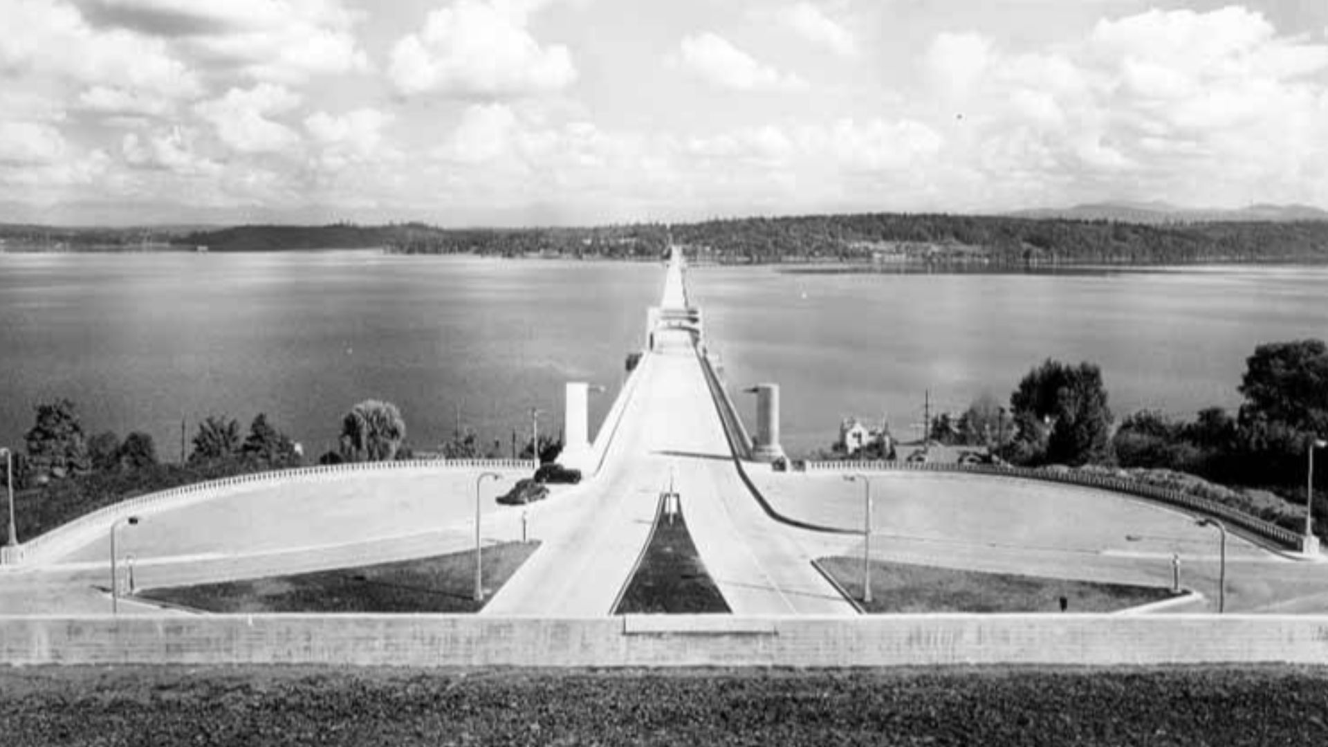 Looking east on the completed Lake Washington Floating Bridge, the only concrete pontoon bridge in the world, Mercer Island, Washington, October 2, 1940. As of 2016, two different similarly constructed pontoon bridges on this location carry Interstate 90 