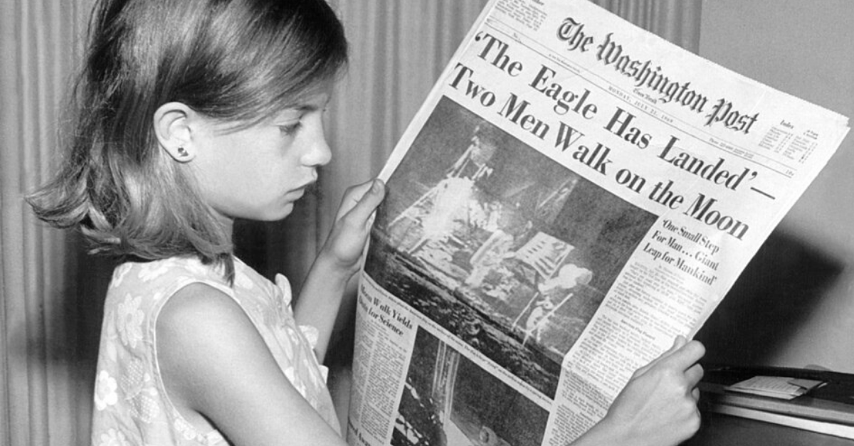 holding The Washington Post newspaper on Monday, July 21, 1969
