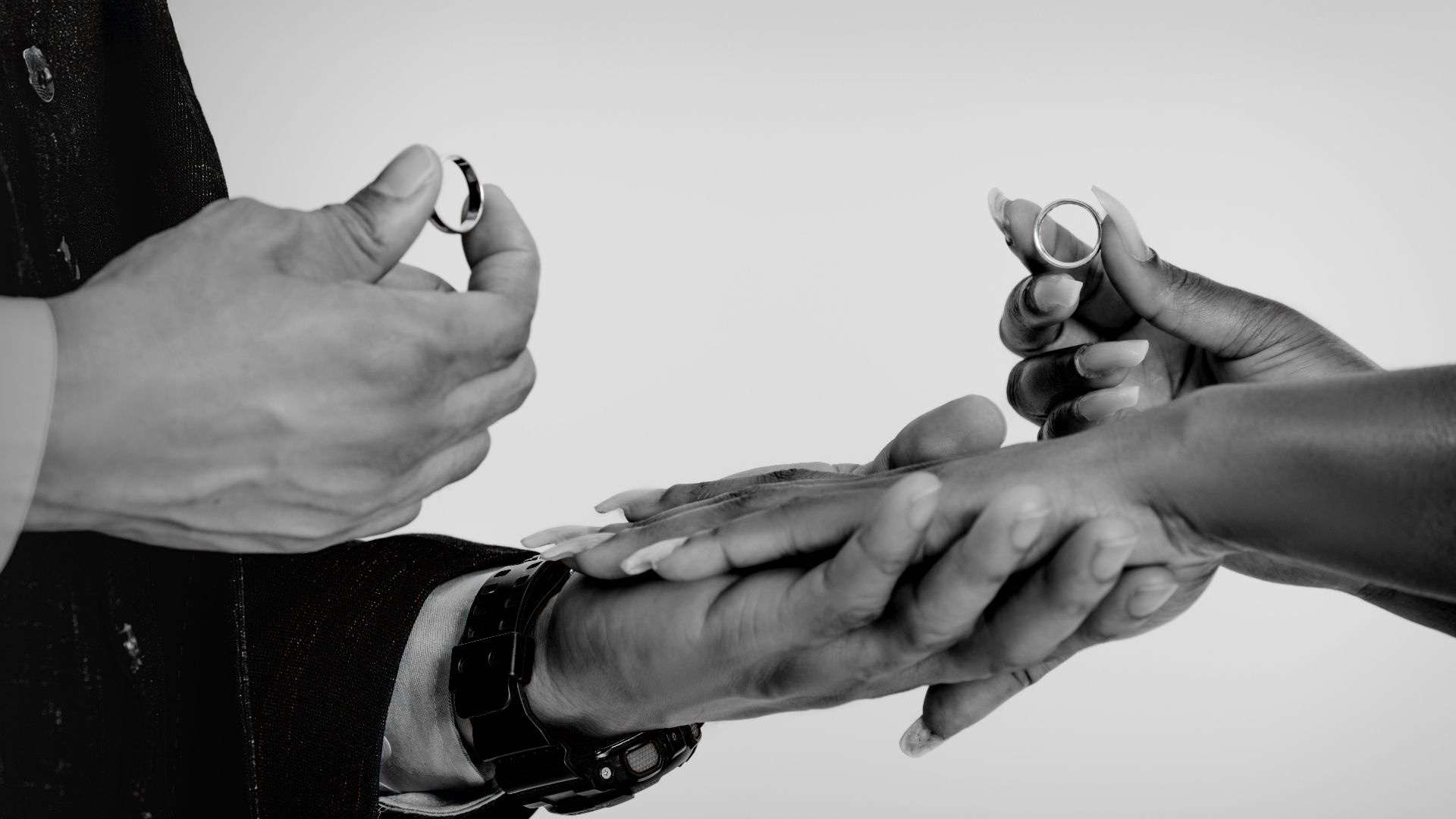 Close-up of hands exchanging wedding rings, symbolizing commitment and love.