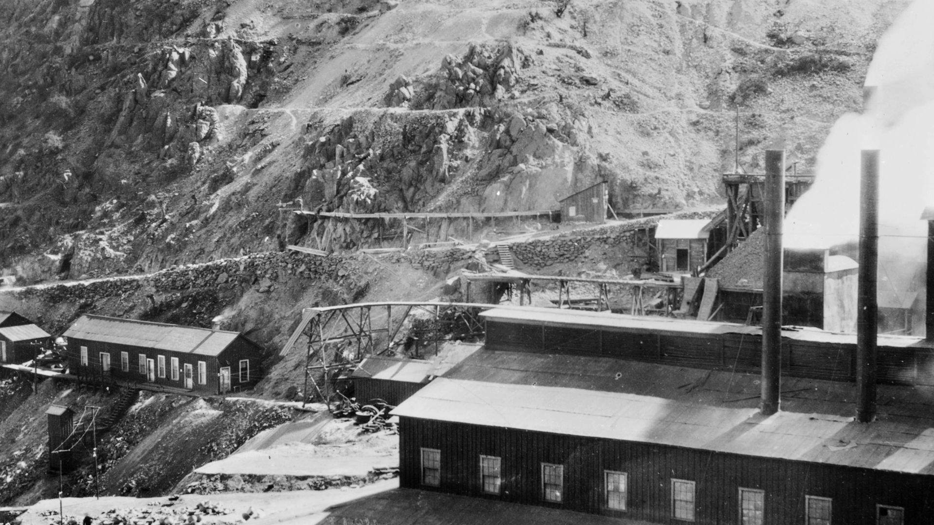 Copper mining town, Bisbee, Arizona, ca.1900
Photograph of a copper mining town, Bisbee (Jerome?), Arizona, ca.1900. Two smokestacks of a large processing shed are visible at right. Several smaller buildings are perched along a ledge of the steep slope of