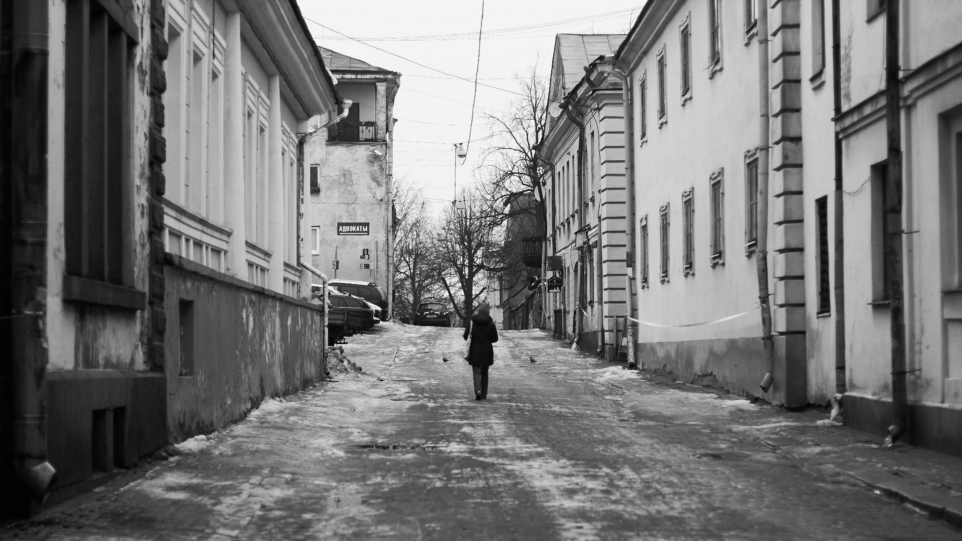 A person walks down a gritty, quiet street.