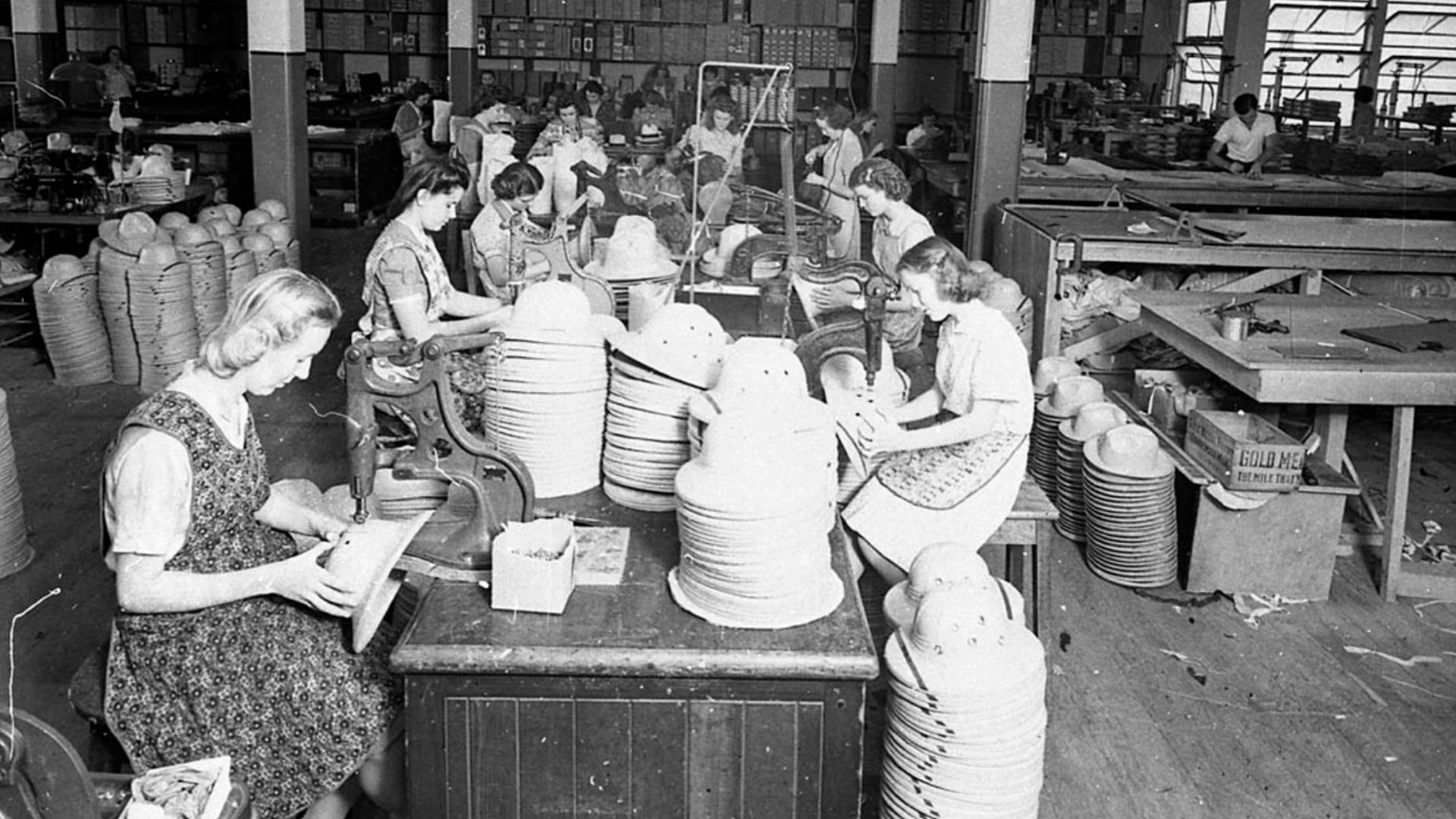 Top Dog factory for men's hats; showing female workers machining the braid