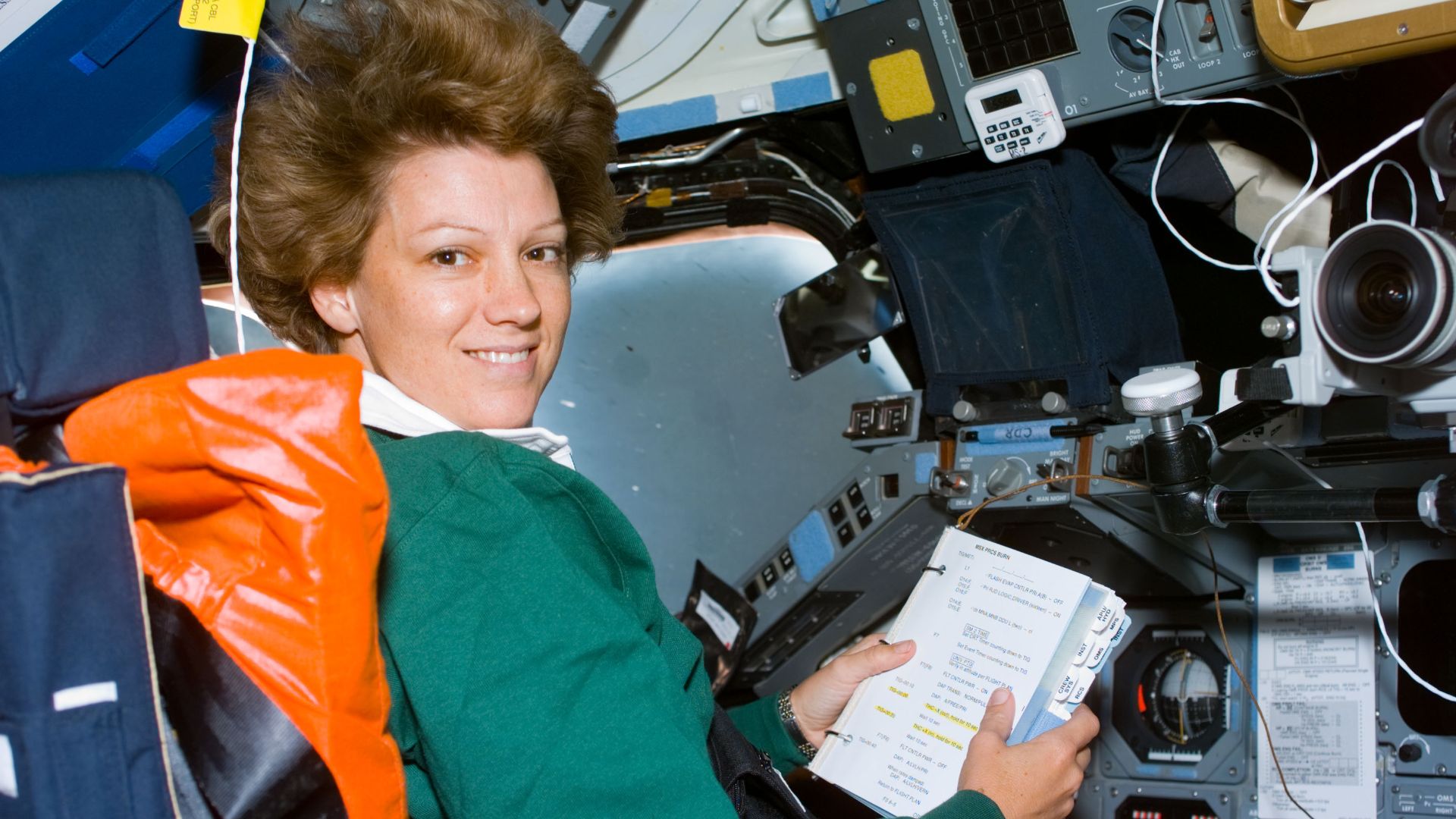 Astronaut Eileen M. Collins, mission commander, looks over a procedures checklist at the commander's station on the forward flight deck of the Space Shuttle Columbia on Flight Day 1. The most important event of this day was the deployment of the Chandra X