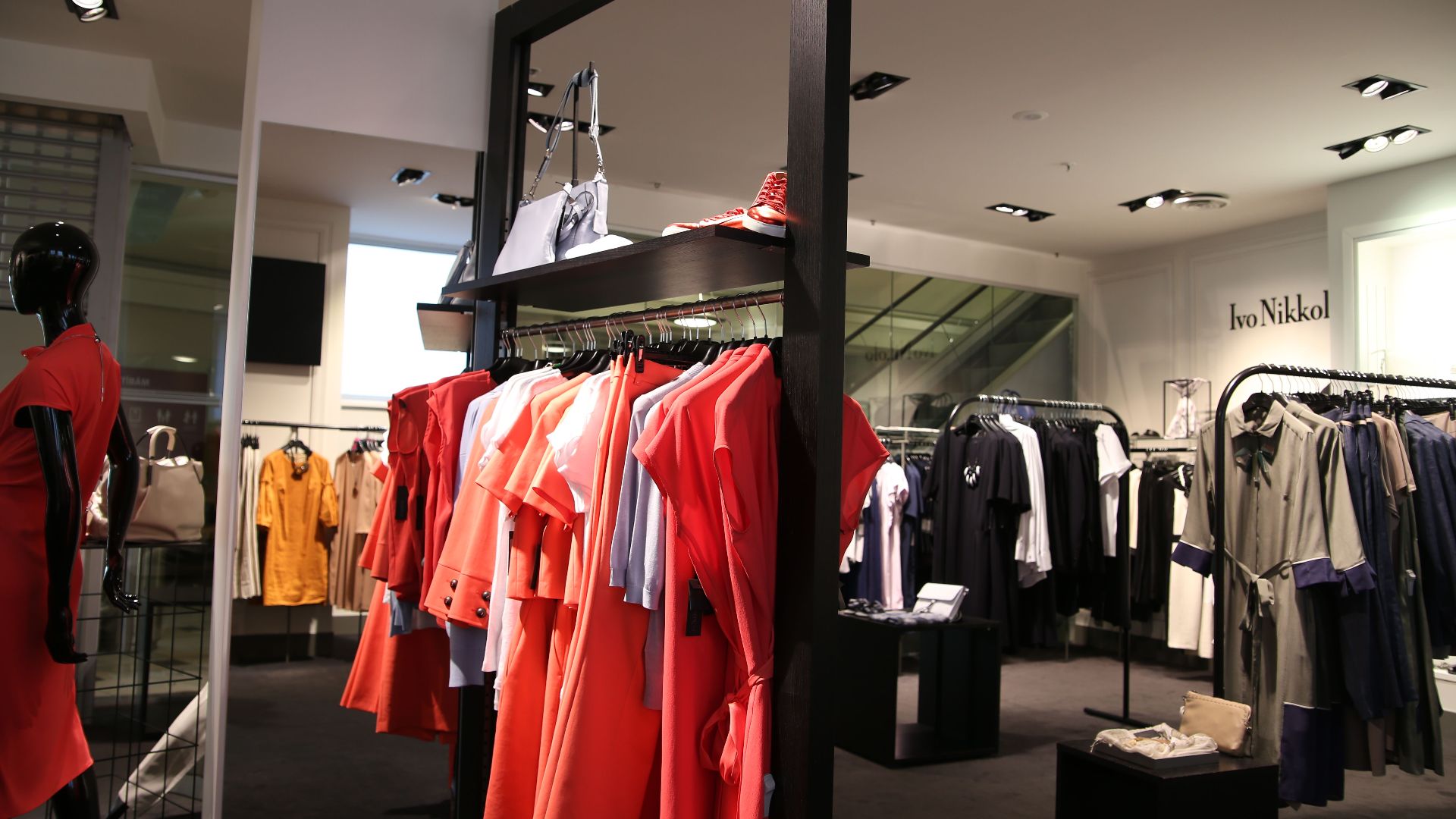 Discover a chic fashion boutique showcasing a variety of colorful clothes on elegant racks.