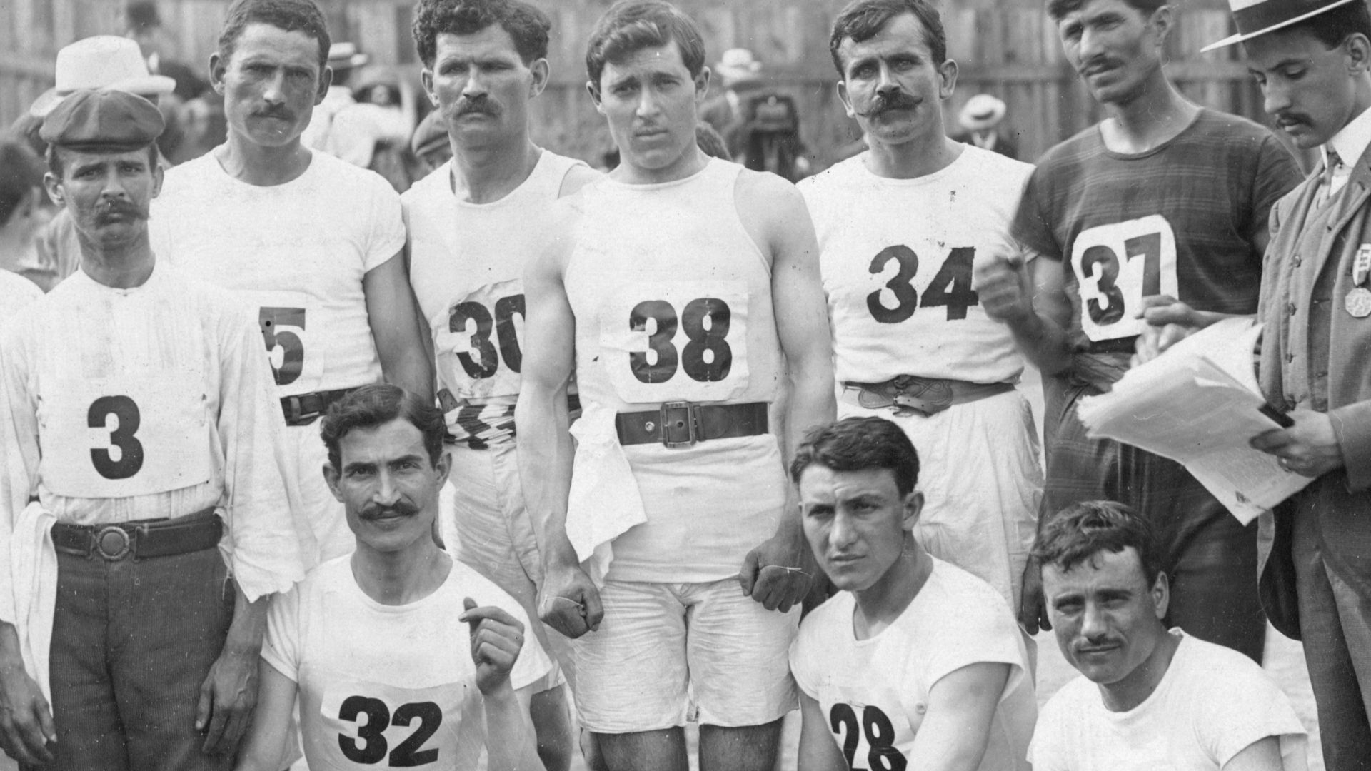 Group of Greek Athletics and Felix Carbejal de Soto [#3] of Cuba posing on track: #3 Felix Carvajal, Cuba; #25 Georgios Vamkaitis, Greece; #30 John/Ioannis Furla, Greece; #38 Ioannis Loungitsas, Greece; #34 Georgios Drosos, Greece; #37 Georgios Louridas, 