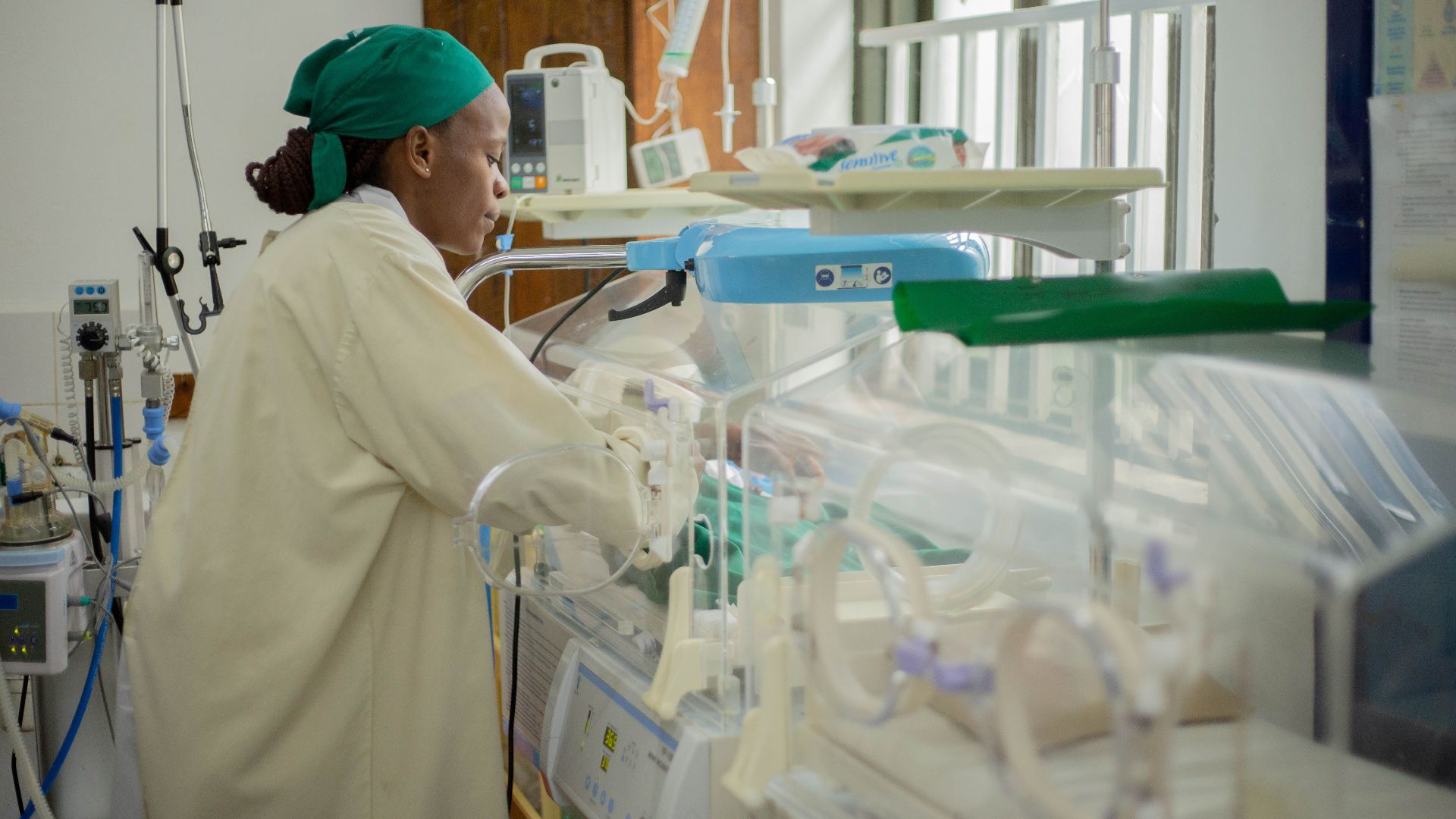 Doctor attending to newborns in an incubator in a hospital neonatal unit.