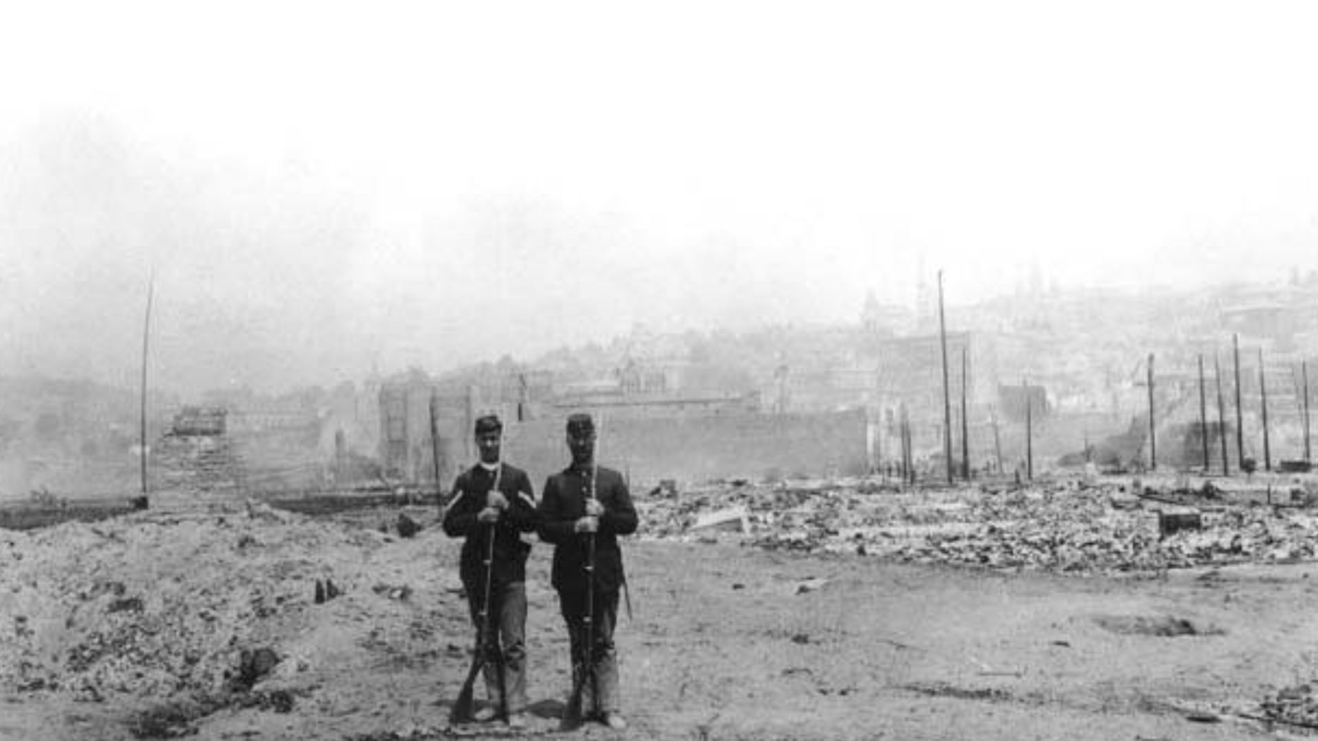 Shows two members of the Washington National Guard
Caption on image: Ruins of Seattle, from wharf, looking east

PH Coll 684.69
Subjects (LCTGM): Ruins--Washington (State)--Seattle; Washington (State). National Guard--People--Washington (State)--Seattle
S