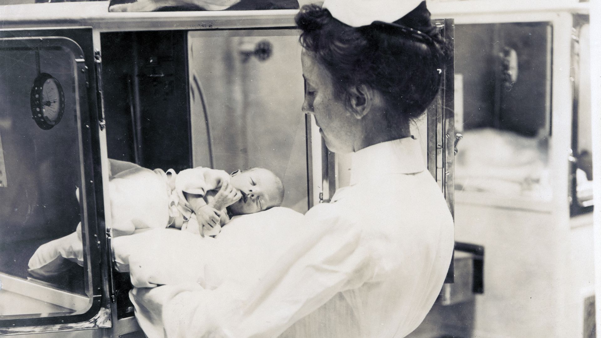 Title: Nurse with an infant in the Baby Incubator exhibit on the Pike at the 1904 World's Fair.