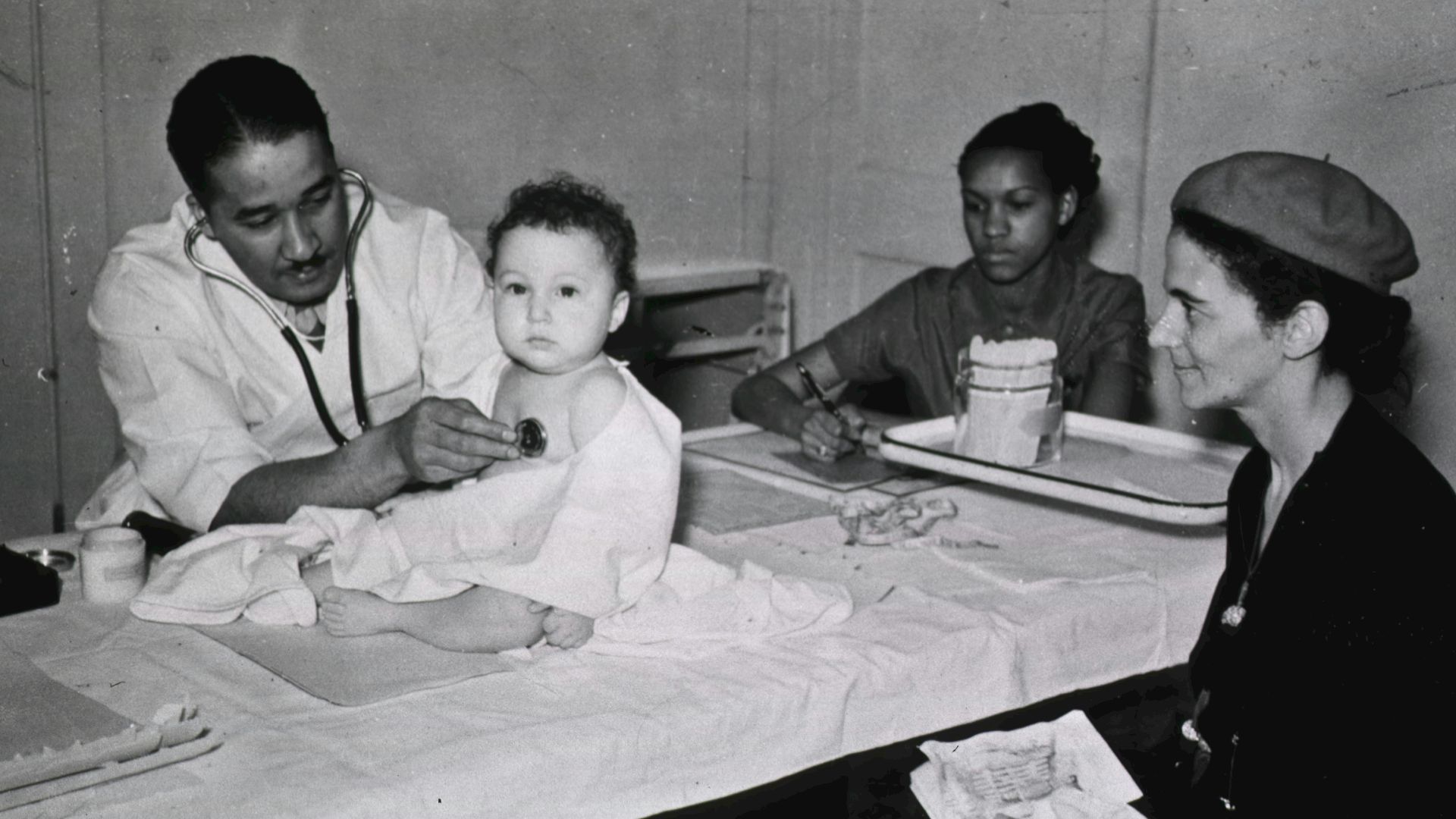 a group of people sitting around a table with a baby