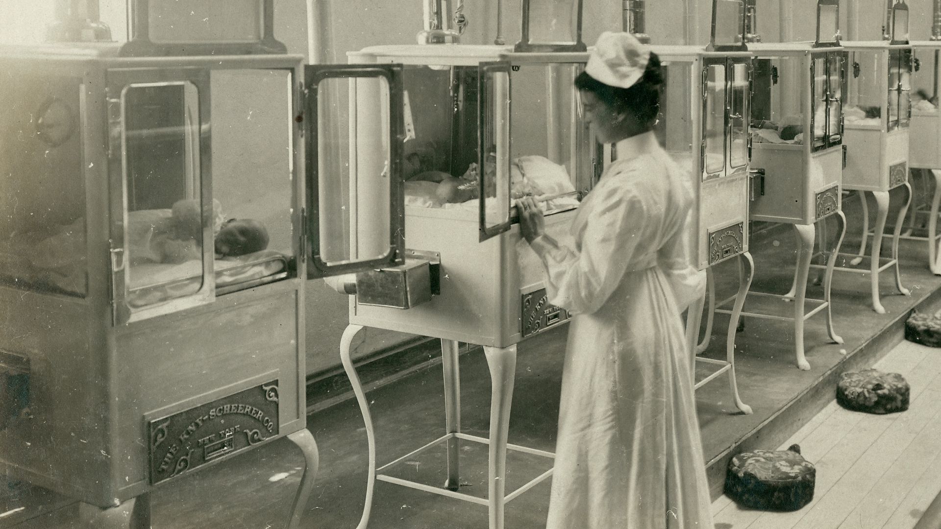 Title: Manager, Mr. E.M. Bayliss and nurses attending babies in the Baby Incubator exhibit on the Pike at the 1904 World's Fair.