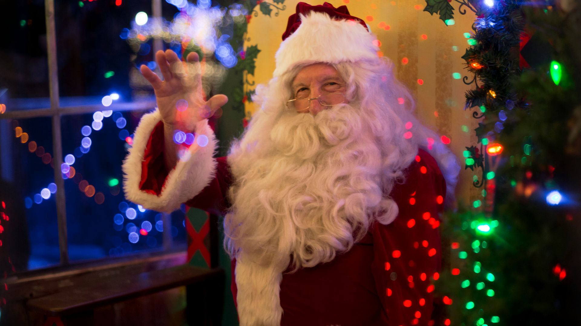 santa claus sitting beside lit tree