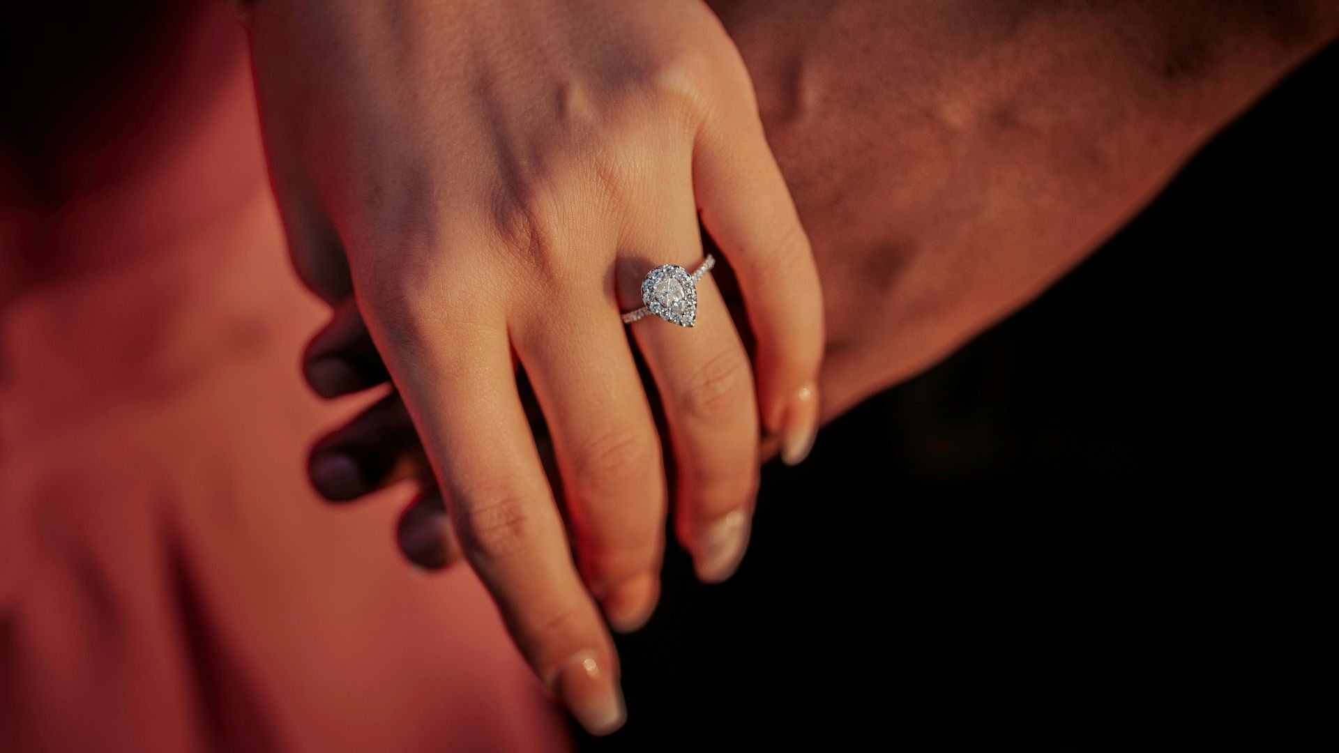 a close up of a person holding a diamond ring