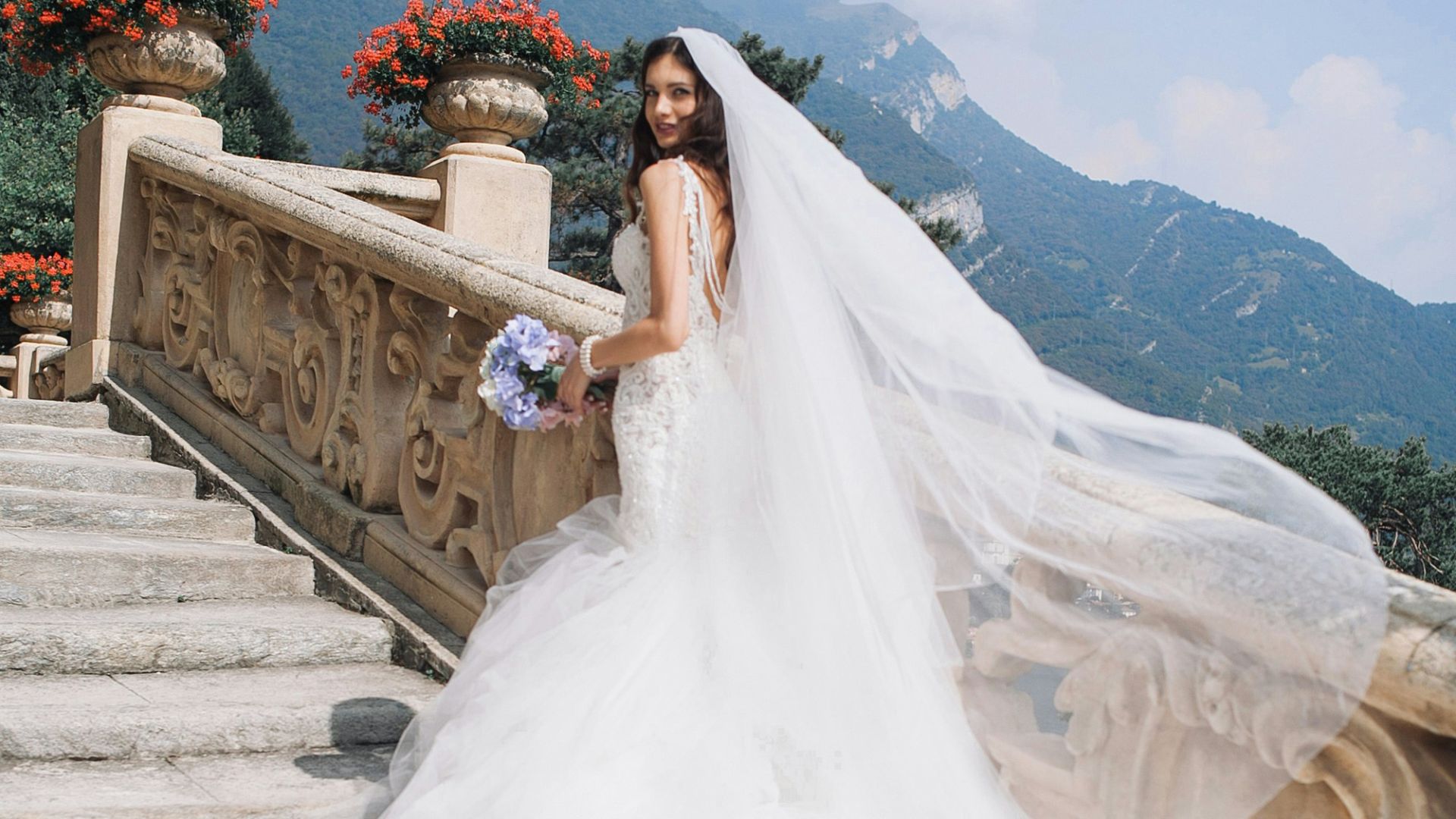 bride holding bouquet standing on white stairs