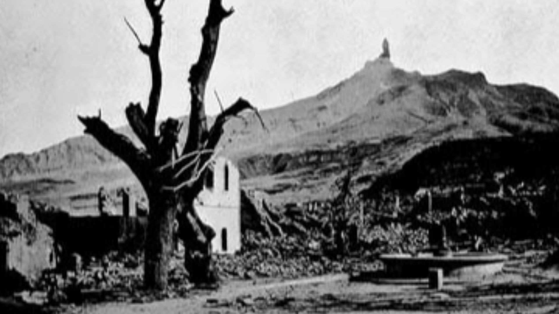Mt. Pelee is also notable for the growth of volcanic spines, rigid columns of solidified lava pushed above the throat of the volcano. This view from the south section of St. Pierre looking up to Mt. Pelee. Note the volcanic spine at the summit of the volc