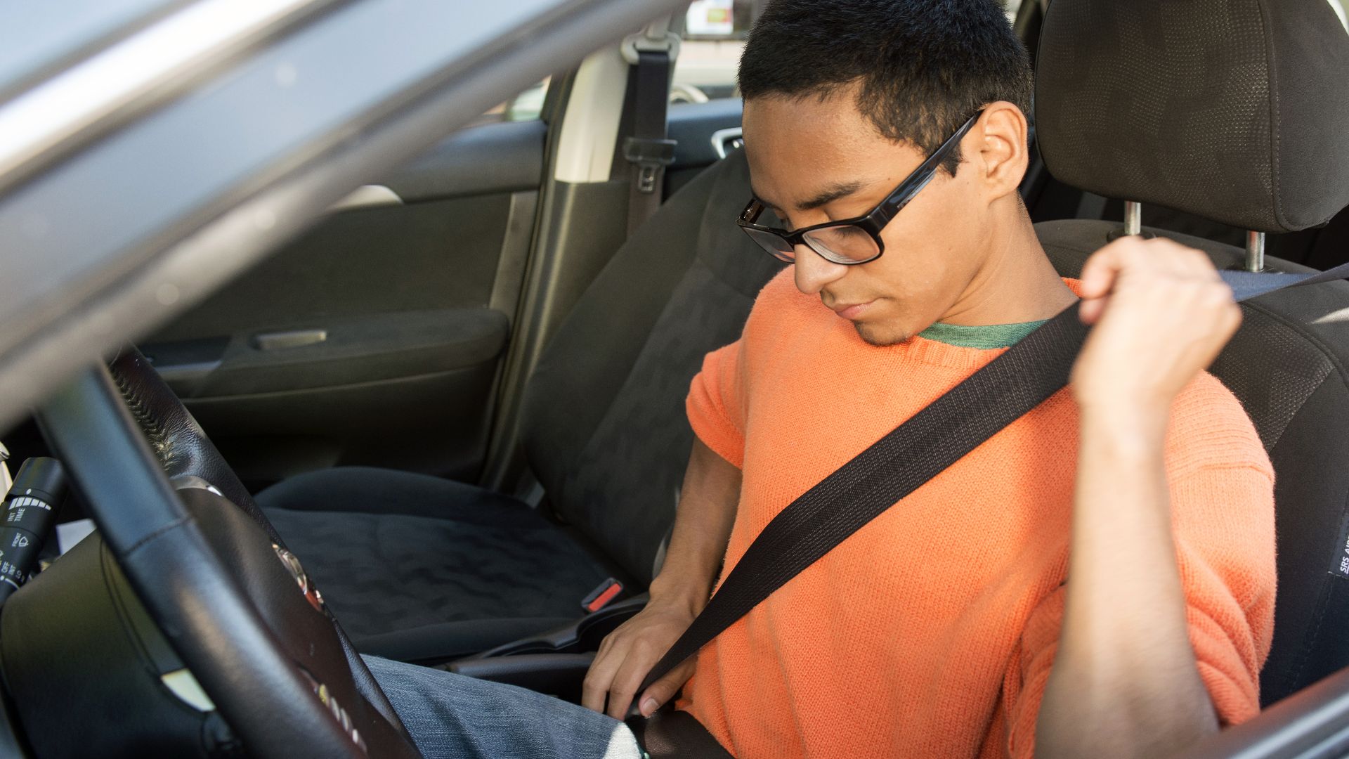 Teen driver buckling up before beginning the drive