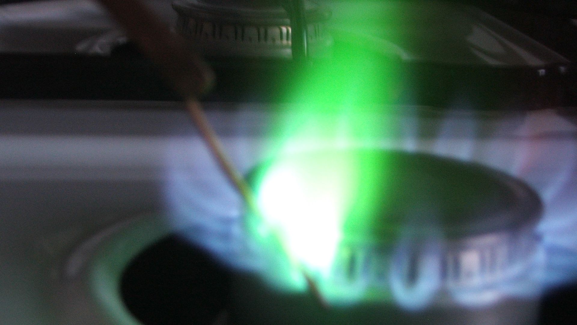 Copper wire in a flame test. The copper wire was previously dipped in HCl. The oxygen oxidizes the copper to copper oxide, which reacts with the hydrogen chloride fumes to make copper chloride, which gives the bright flame test color.