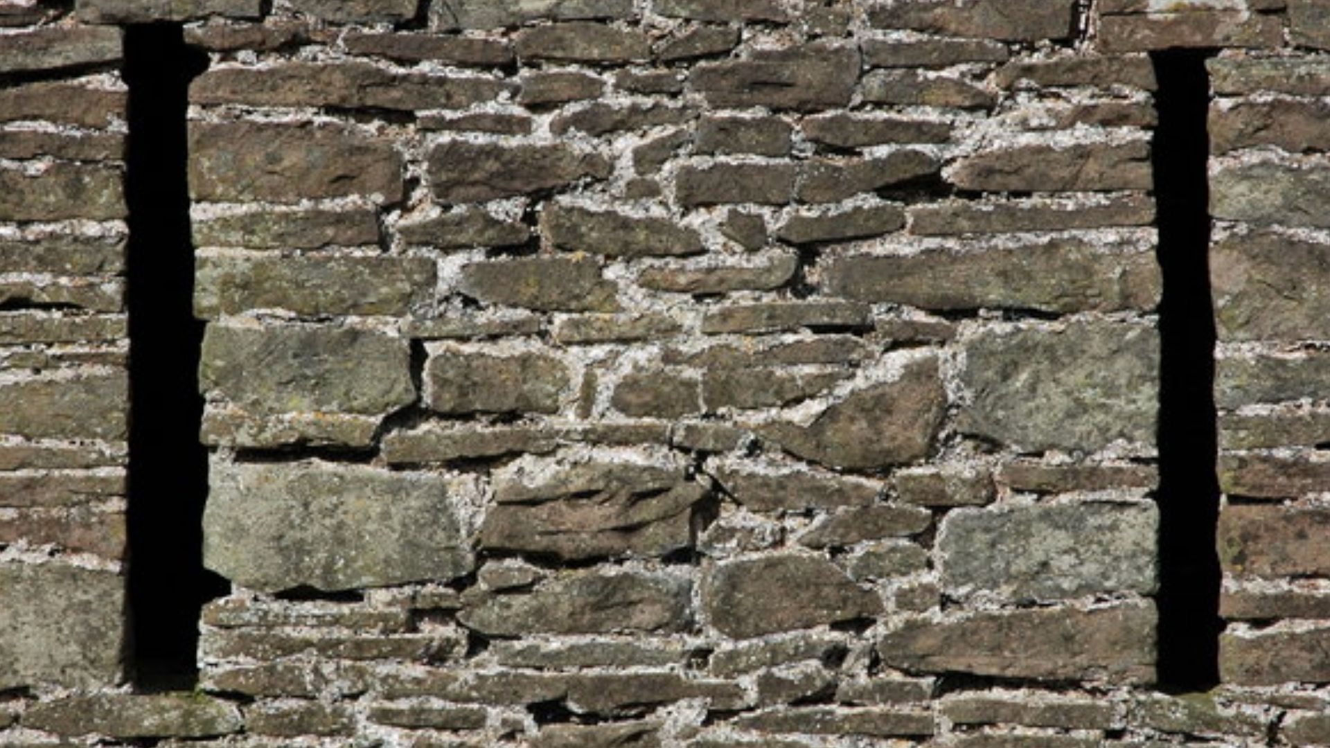 Ventilation holes in a stone barn The narrow ventilation slits in the wall of a stone barn above the village of Ganarew are very reminiscent of arrow slits in a medieval castle.