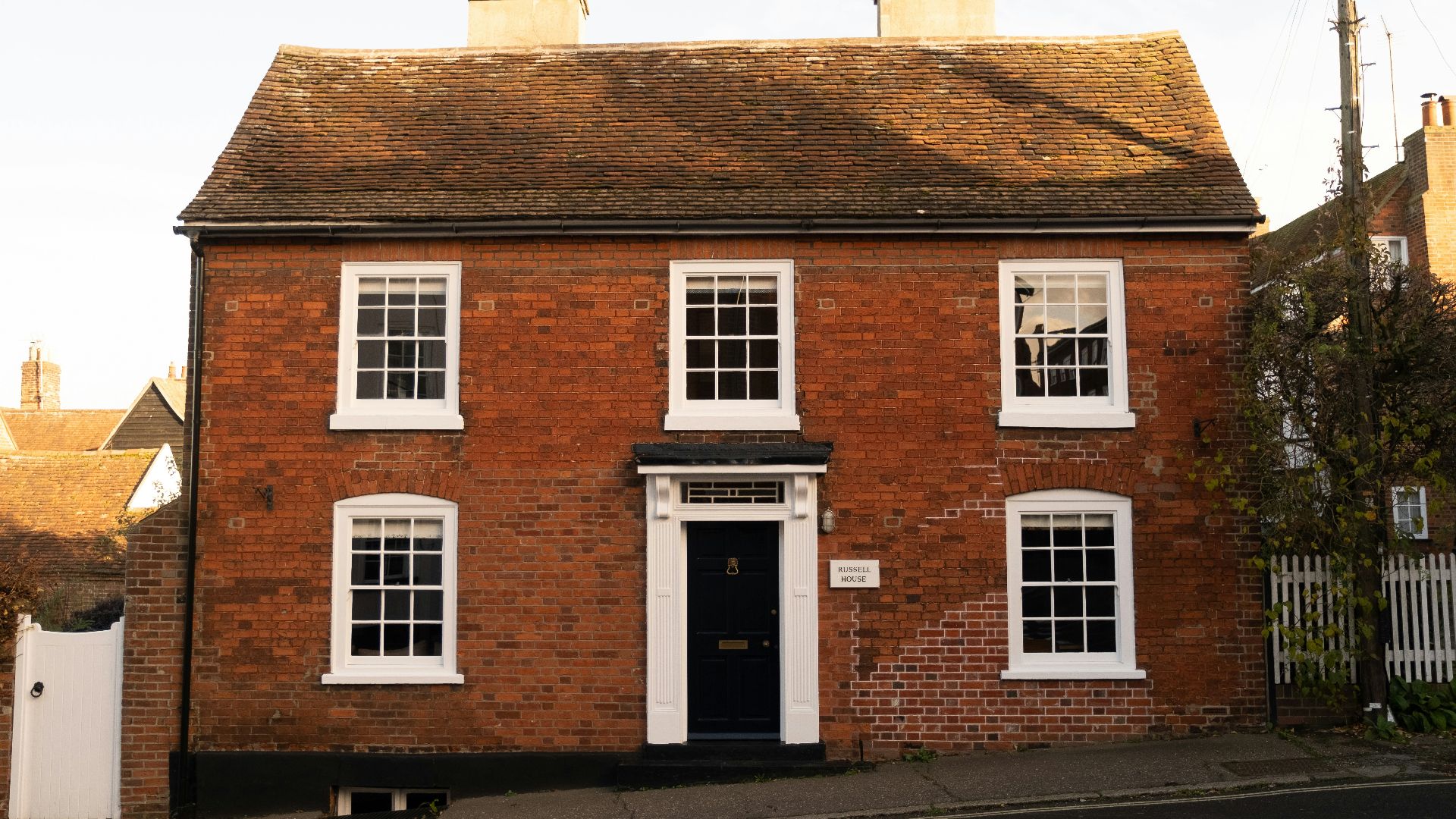 A red brick house with white windows and a black door