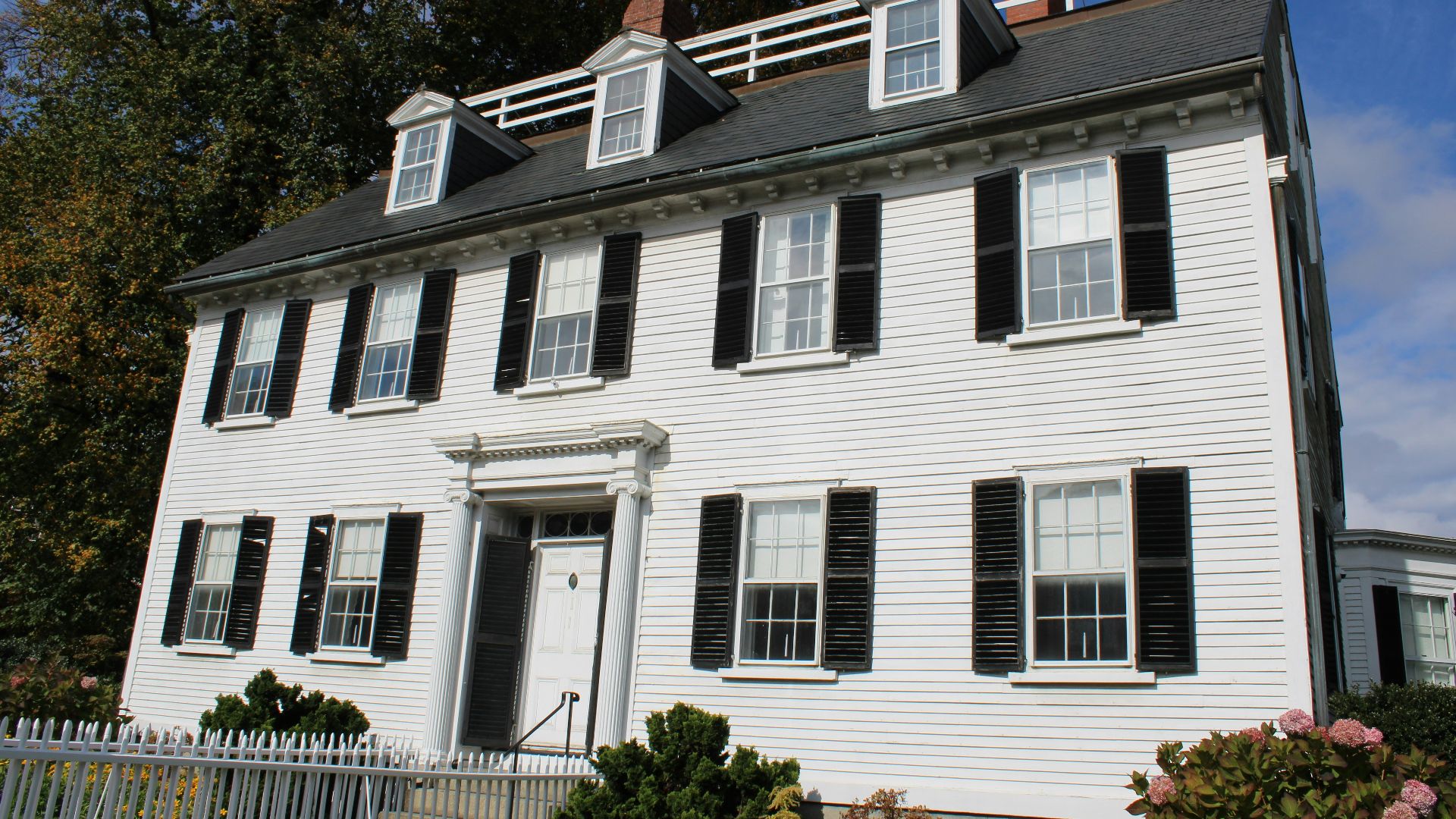 A white colonial house with black shutters
