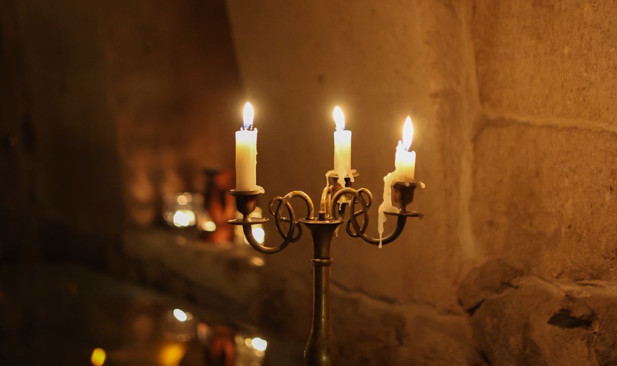 Elegant candlelit scene in a rustic setting with warm tones and classic decor.