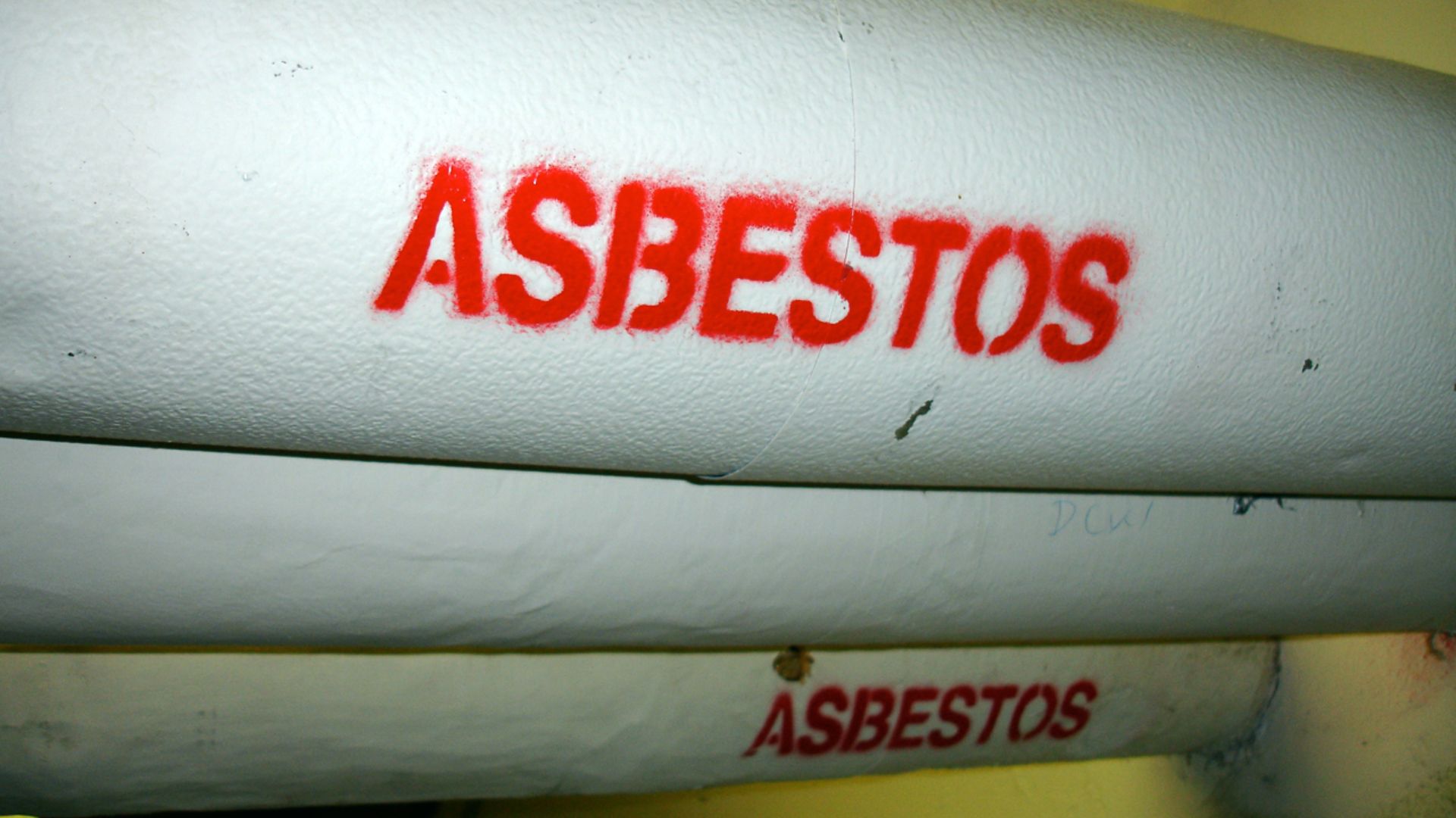 One of many pipes on campus wrapped in asbestos insulation, clearly marked.