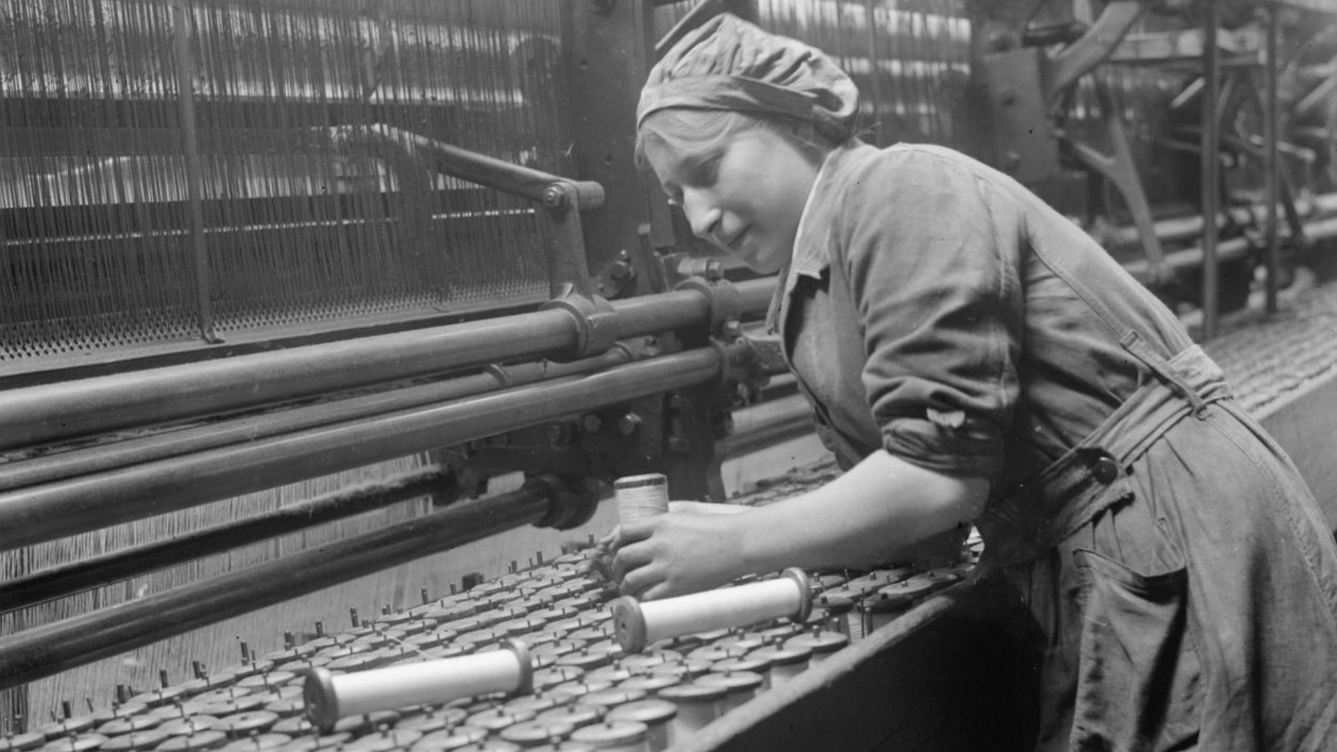 Industry during the First World War- Leicestershire
A female worker replaces empty spools of thread in a lace curtain machine in a Nottingham factory in September 1918.