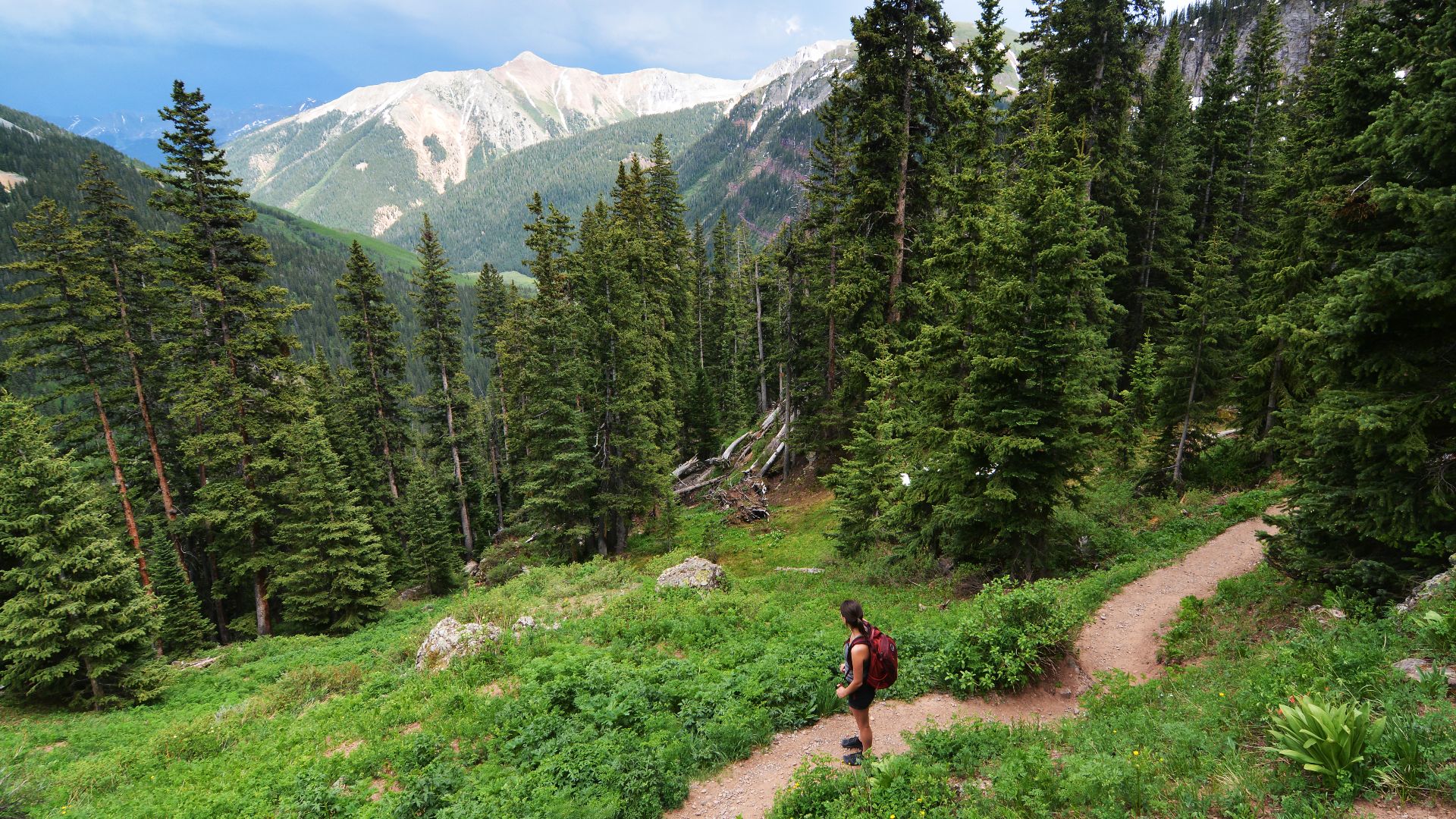 A hiker ascending toward Lower Ice Lake Basin, in Colorado's San Juan National Forest