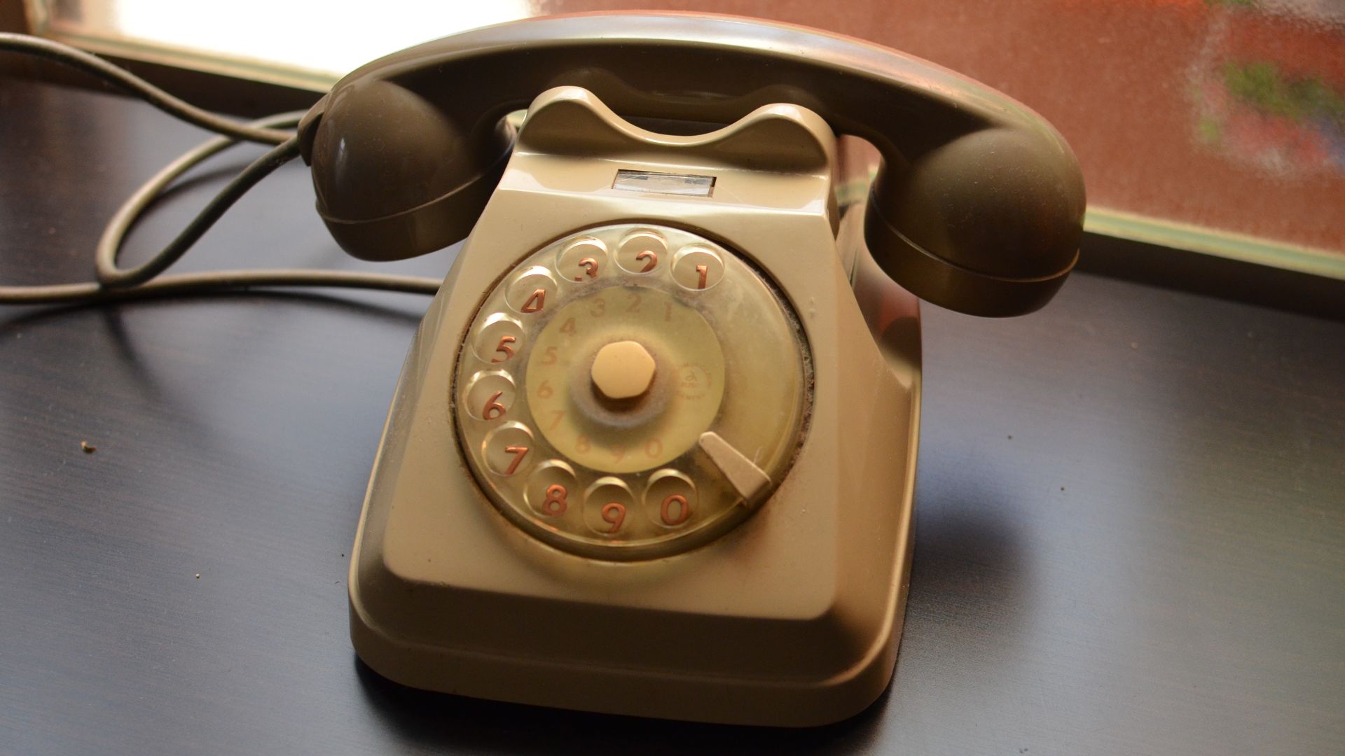 Een ouderwetse telefoon met draaischijf.