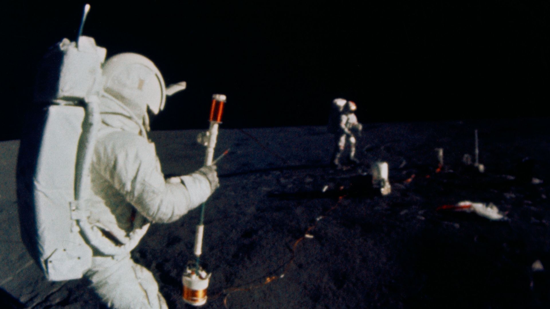 S71-19509 (5 Feb. 1971) --- Astronaut Edgar D. Mitchell, lunar module pilot, operates the Active Seismic Experiment's (ASE) thumper during the first Apollo 14 extravehicular activity (EVA) on the moon. Astronaut Alan B. Shepard Jr., commander, walks near 