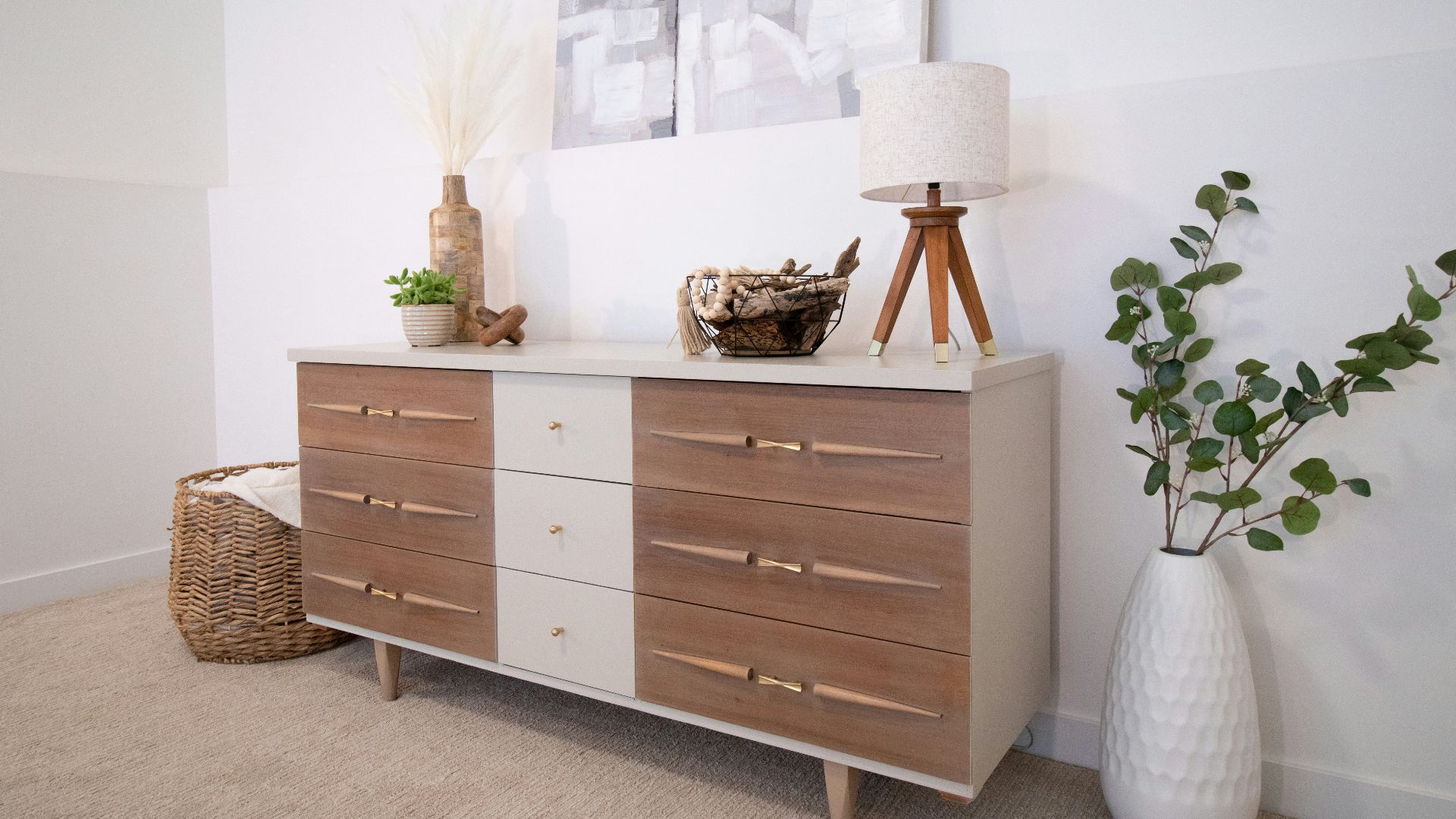 A white vase sitting on top of a wooden dresser