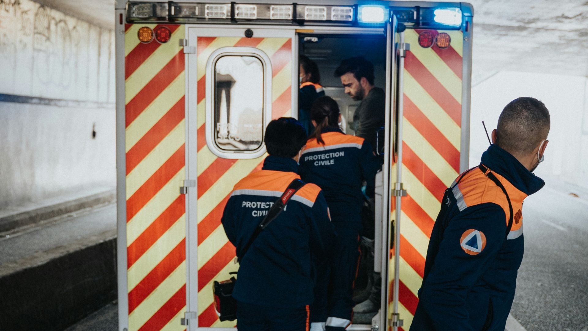 a couple of men standing next to an ambulance