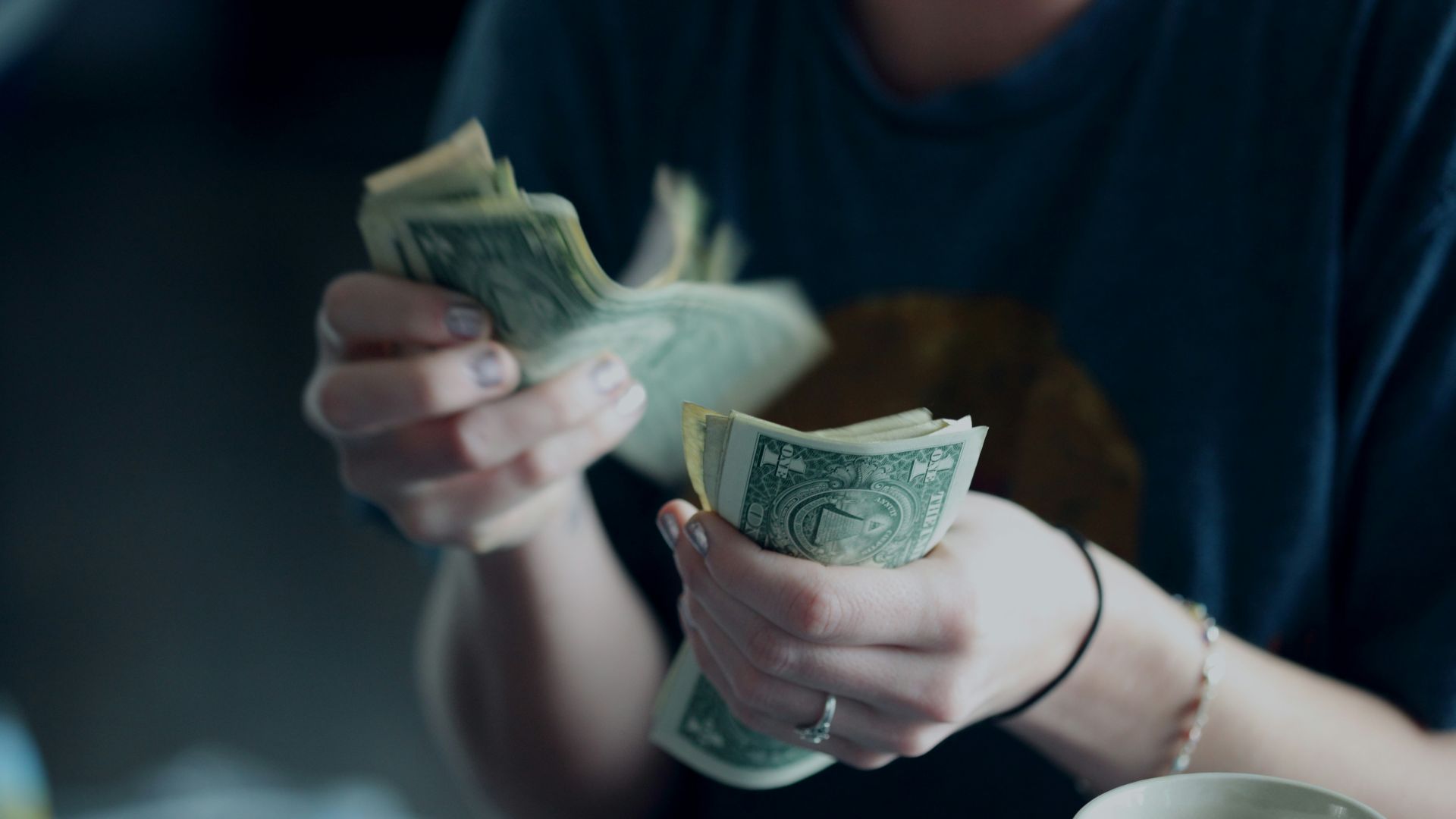 focus photography of person counting dollar banknotes