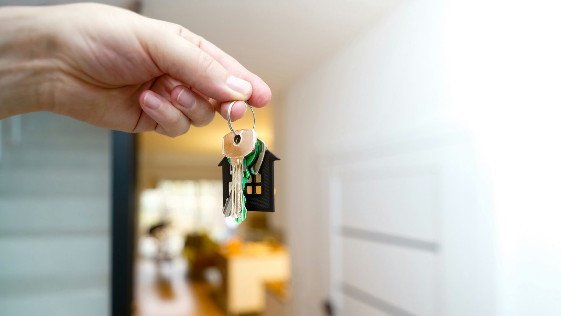 Holding house keys in front of the entrance.