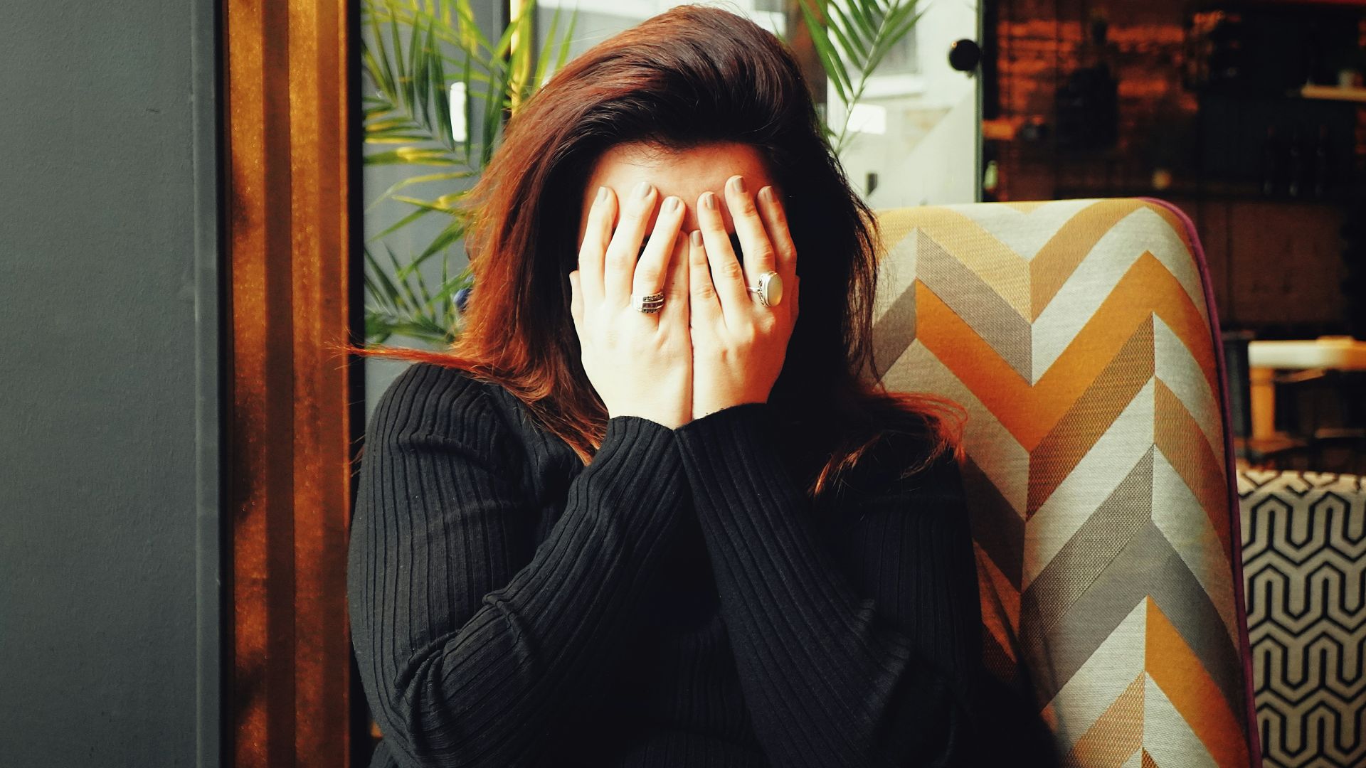 woman in black long sleeve shirt covering her face