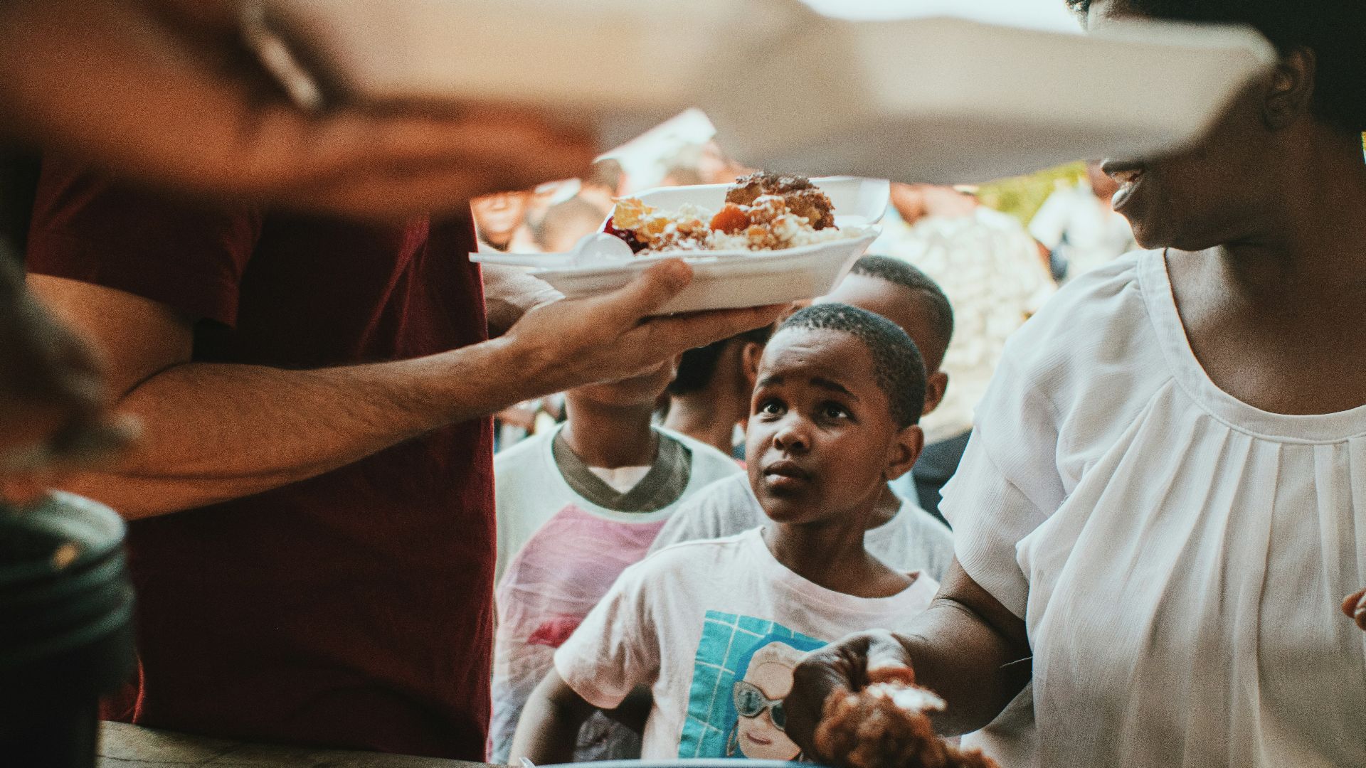 a group of people holding plates of food
