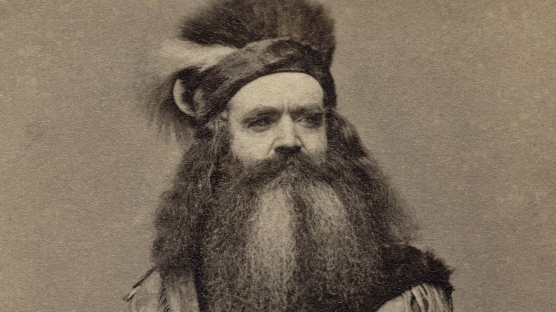 Seth Kinman, California hunter and trapper, who presented President Lincoln with the Elk Horn Chair. Three-quarters length portrait, seated in chair. Carrying rifle and wearing fringed buckskin outfit.